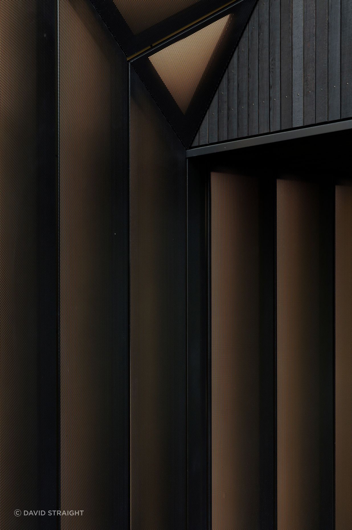Perforated metal screens adopt the metaphor of a shirt cuff to define the entry. 