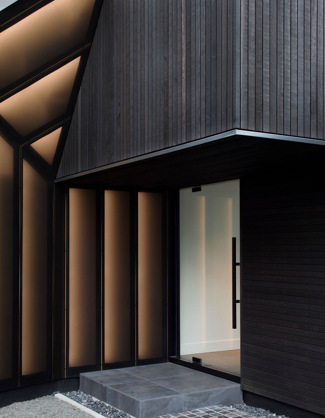 A cedar-cladd overhang provides shelter over the front entrance.