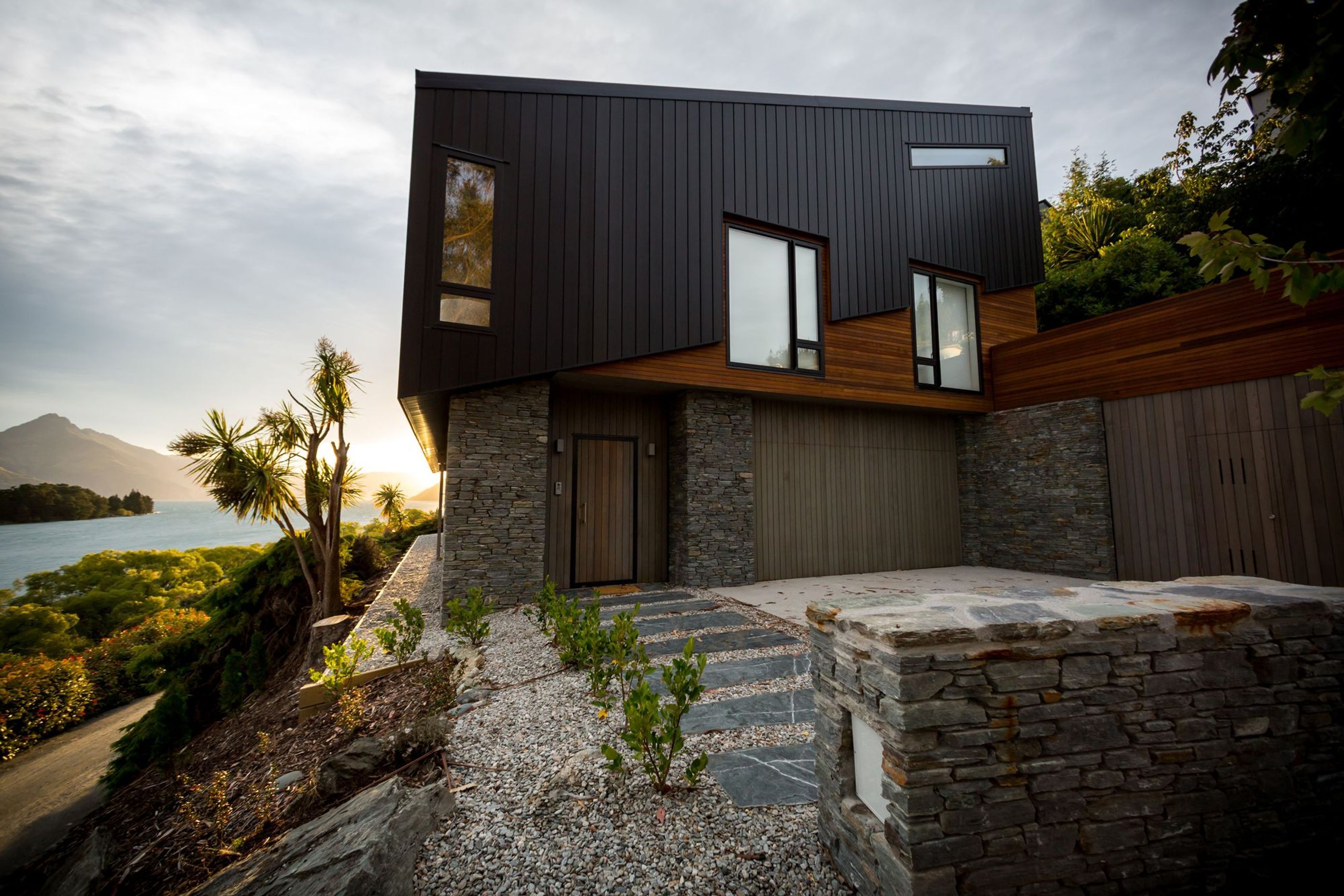 Schist cladding on the lower level helps anchor the house to the site while cedar and aluminium cladding was used to explore the tilt and shift of the topography.
