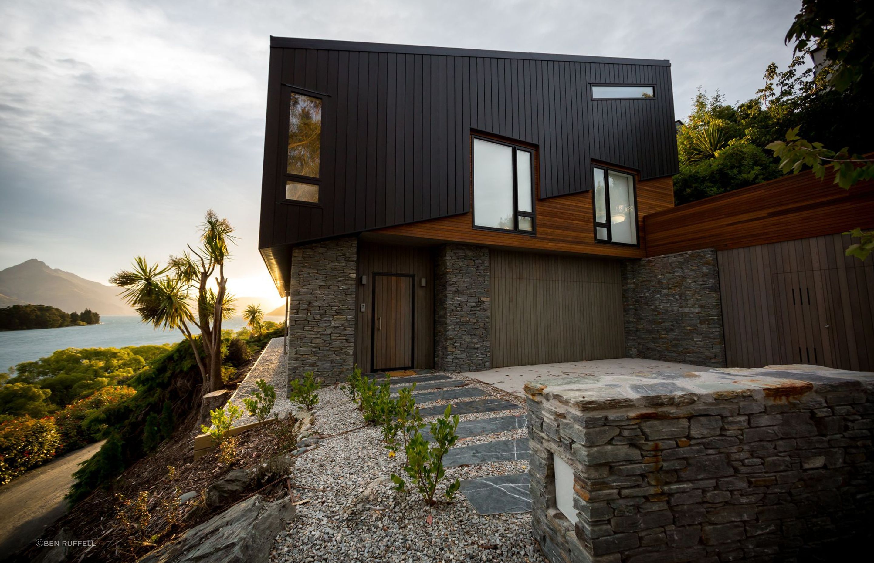 Schist cladding on the lower level helps anchor the house to the site while cedar and aluminium cladding was used to explore the tilt and shift of the topography.