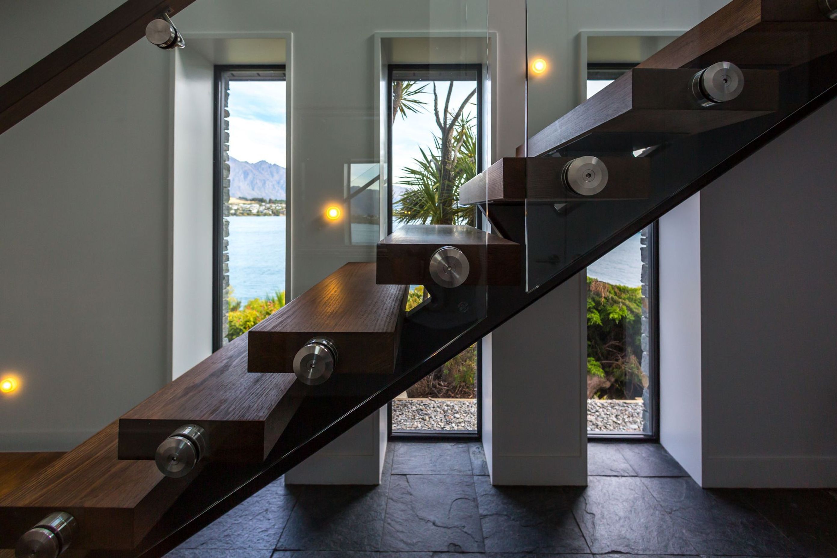 Deep recesses speak to the thermal capacity of the home while the floating timber staircase adds a dramatic flair to the entry.