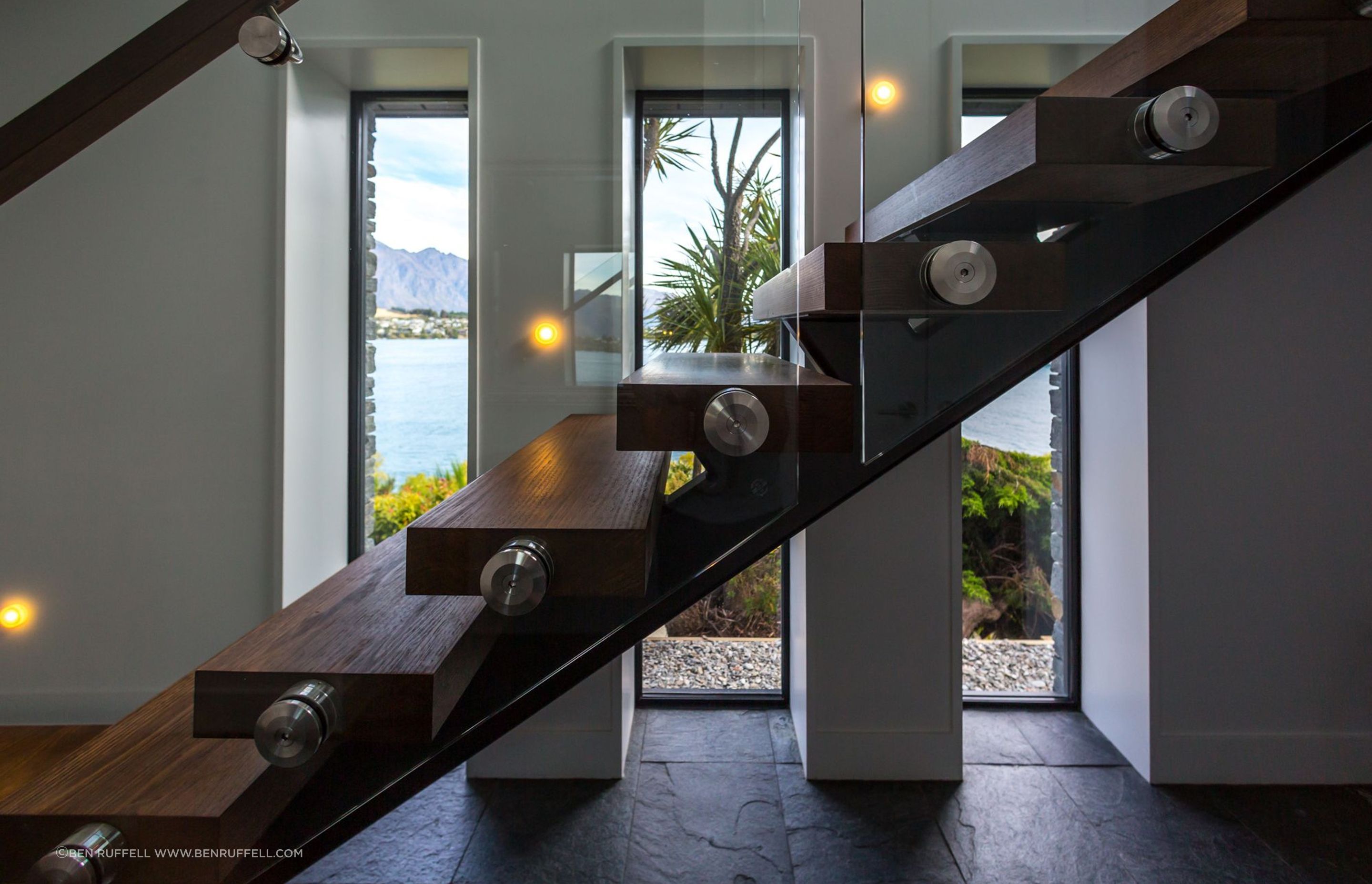 Deep recesses speak to the thermal capacity of the home while the floating timber staircase adds a dramatic flair to the entry.