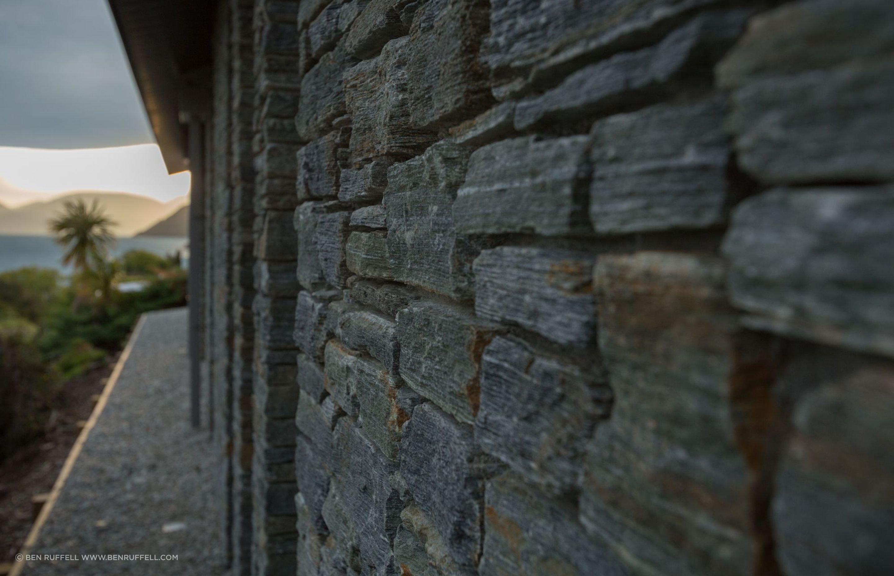 At ground level, stone walls anchor the building against prevailing winds and recognise the rock forms of the hillside.