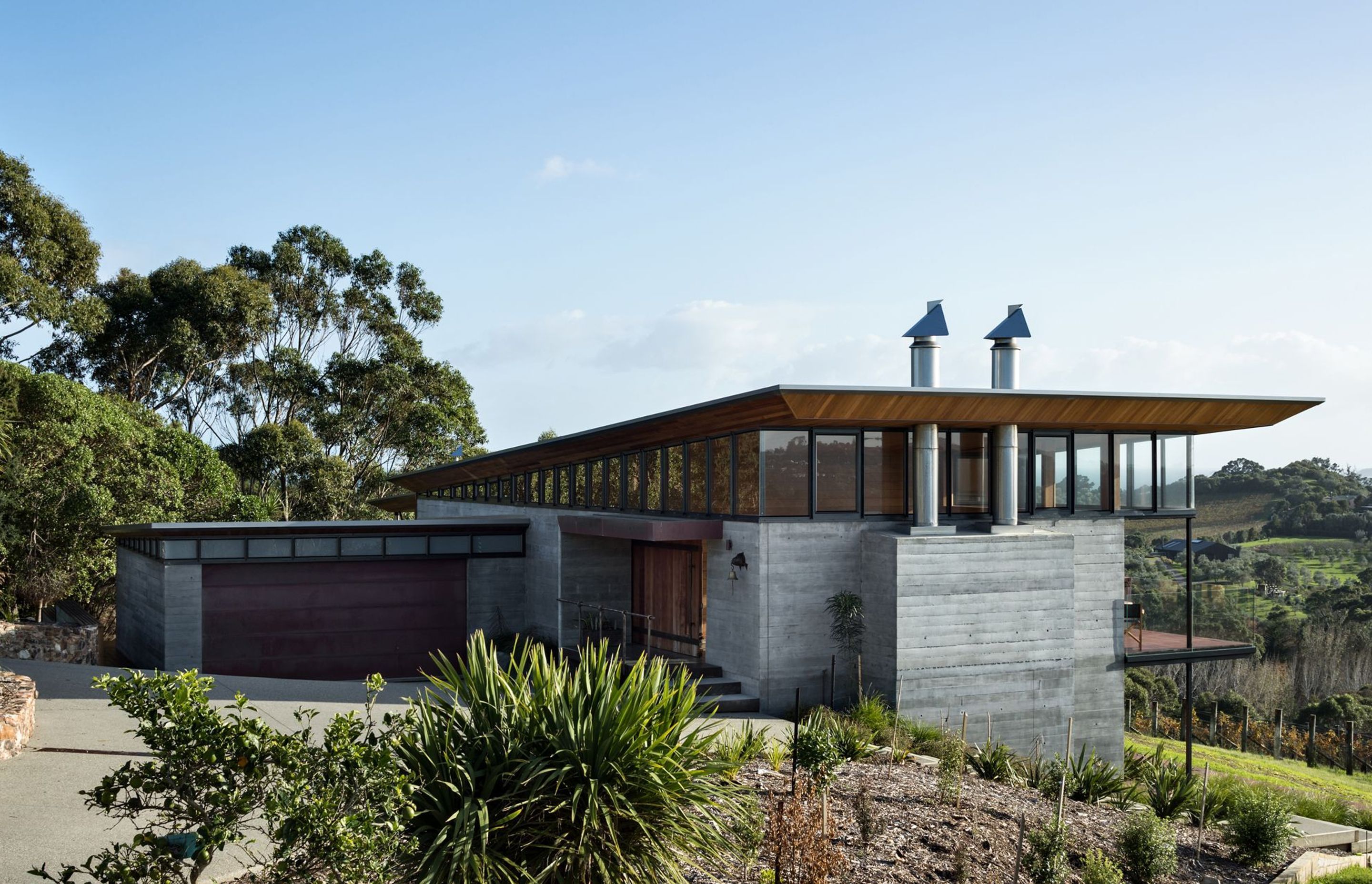 Oneroa House is partly built on the foundations of a previous building, laid out to follow the contours of the land and with a sloping roof that appears to float over clerestory windows.