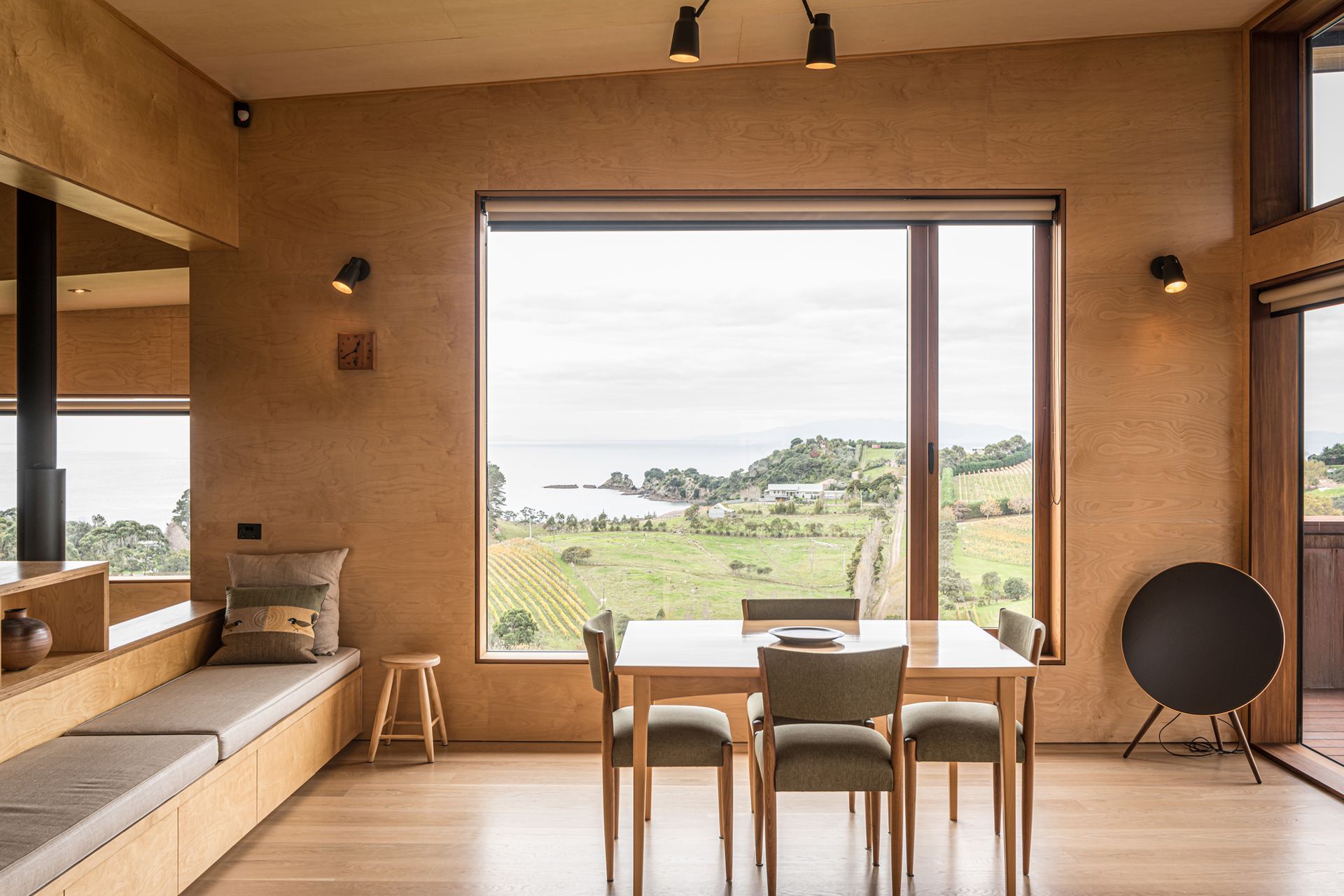 Overlooking the vineyard, a casual dining area is lined in elite birch plywood by Plytech and American white oak flooring to match the rest of the home. Photograph by ArchiPro.