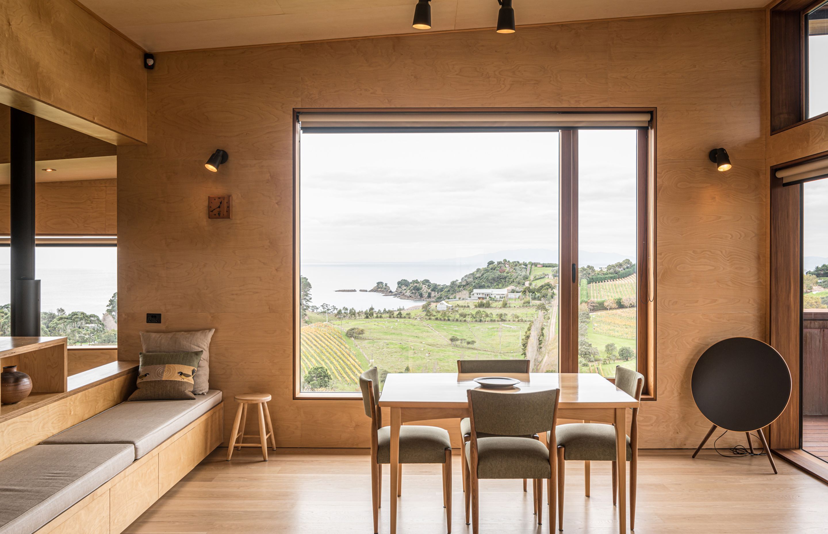 Overlooking the vineyard, a casual dining area is lined in elite birch plywood by Plytech and American white oak flooring to match the rest of the home. Photograph by ArchiPro.