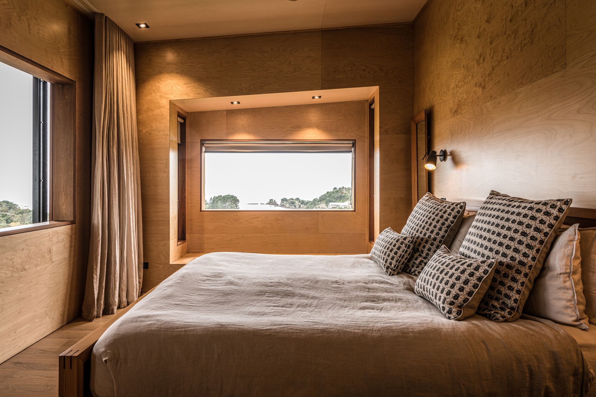 The master bedroom features ocean views and a sliding window that overlooks a second lounge, a library and a study. Photograph by ArchiPro.