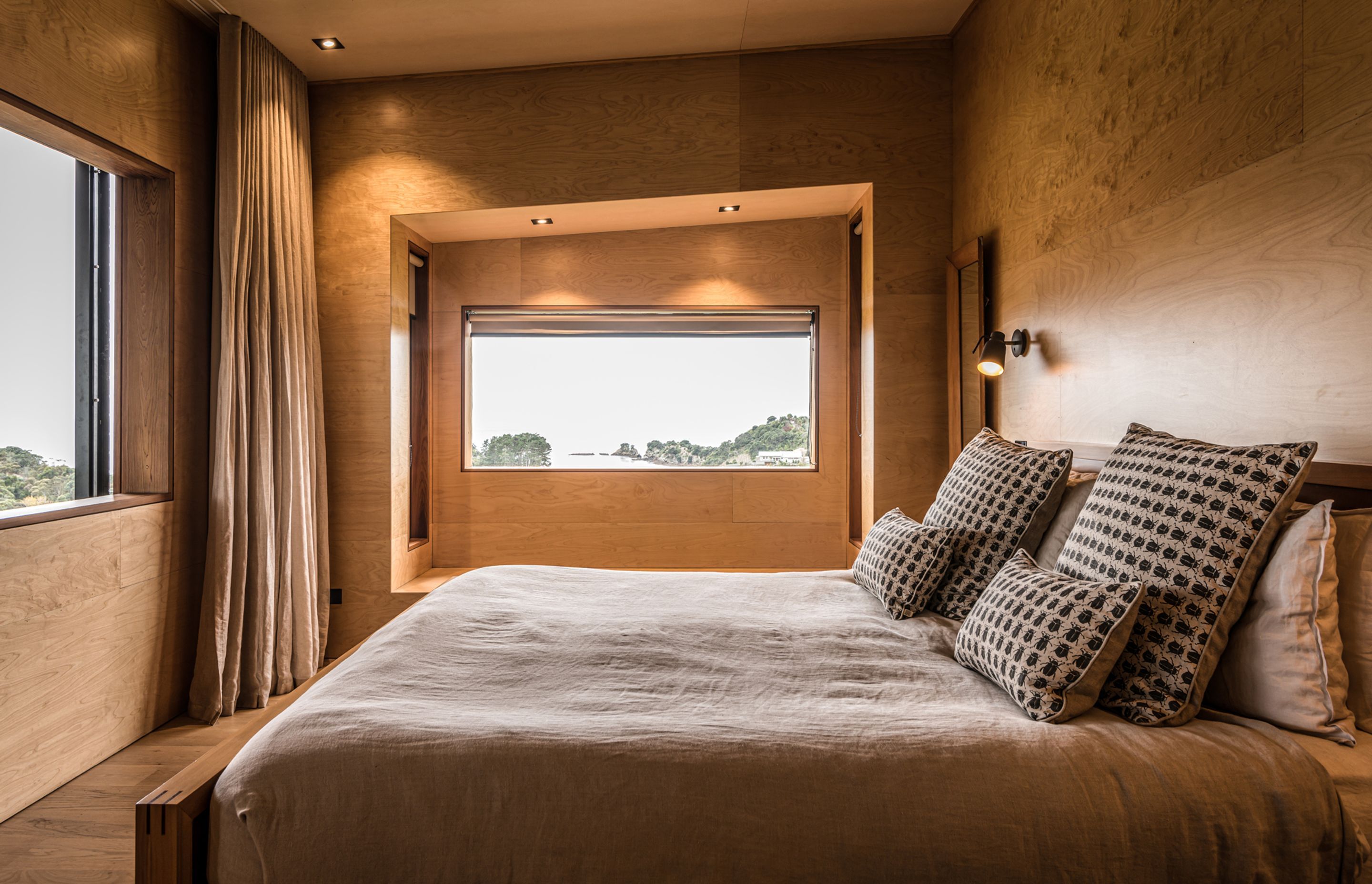 The master bedroom features ocean views and a sliding window that overlooks a second lounge, a library and a study. Photograph by ArchiPro.