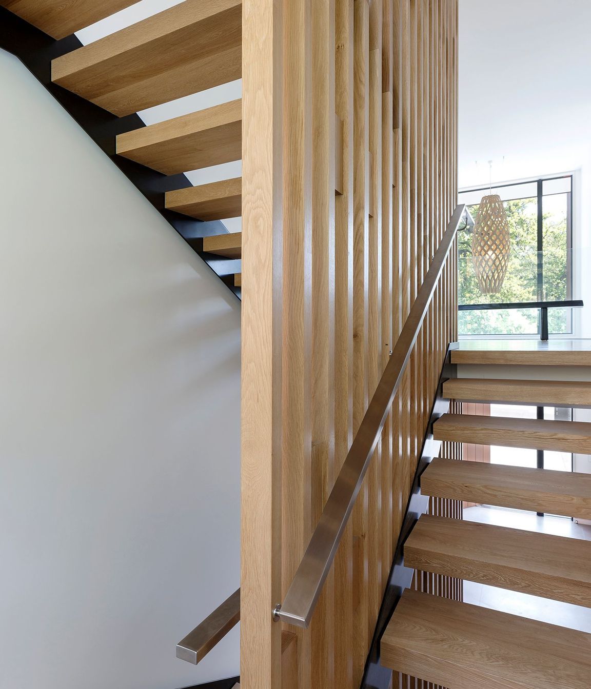 An American white oak timber stairwell links three storeys of the house.