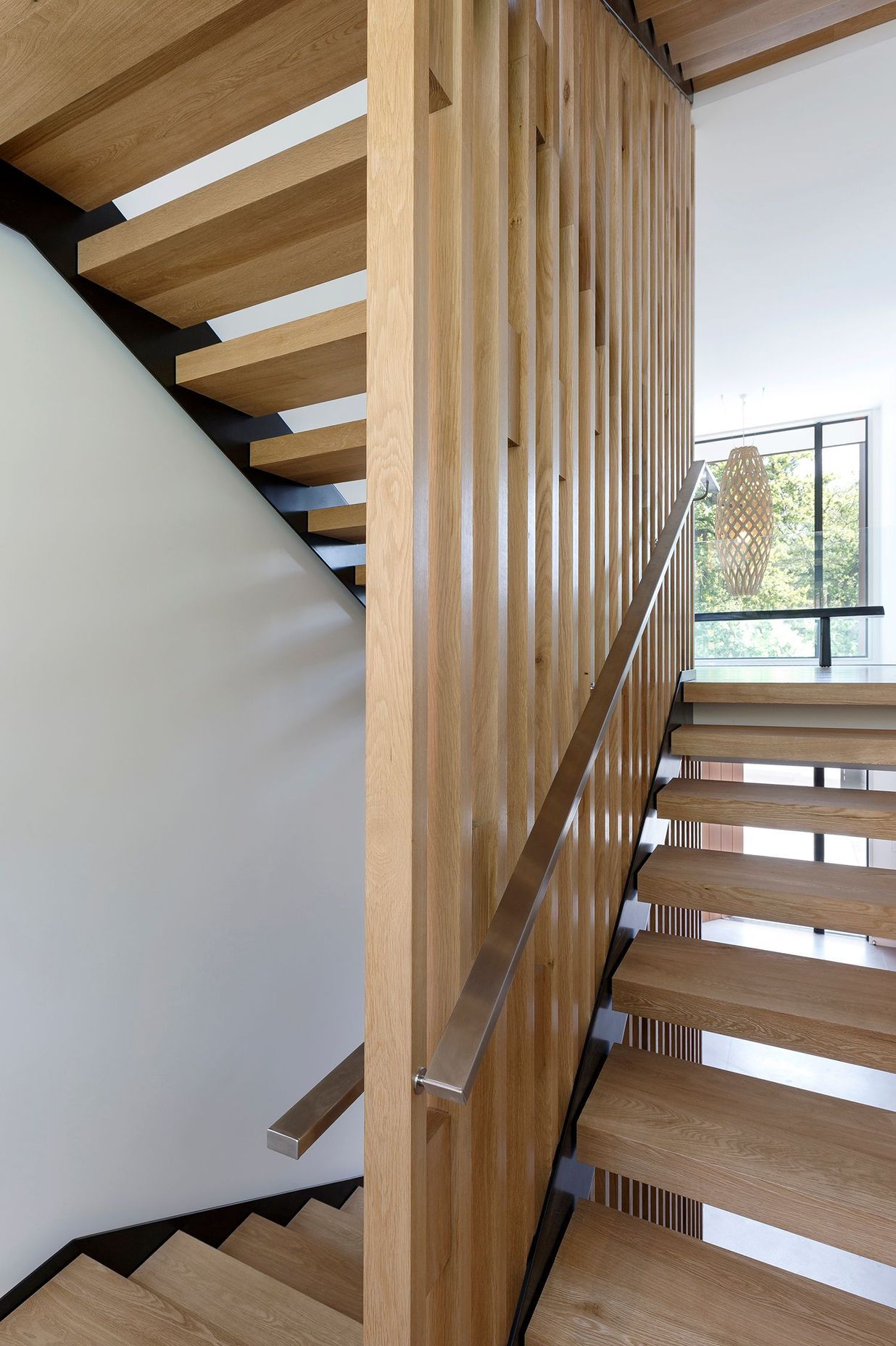 An American white oak timber stairwell links three storeys of the house.