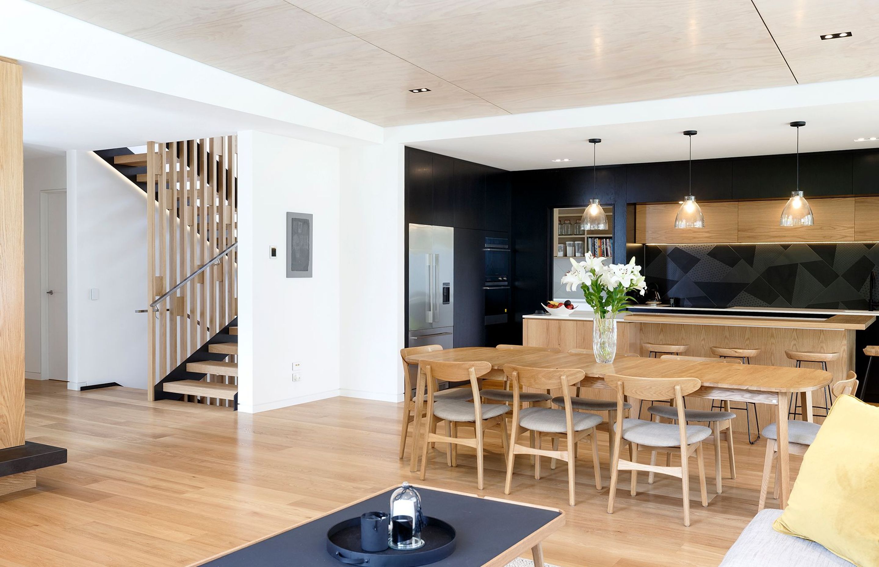 The view from the lounge towards the feature staircase, kitchen and dining area.