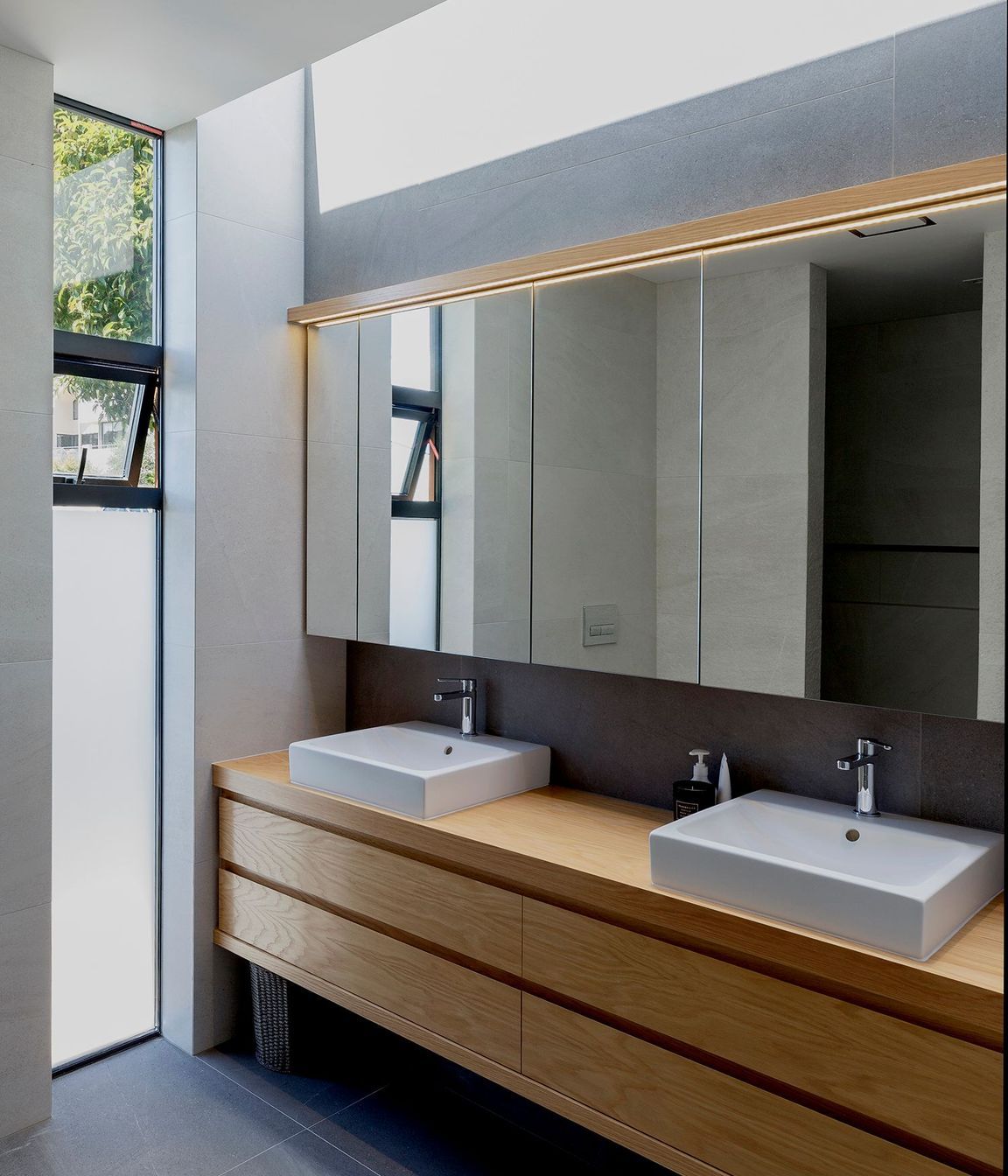 The bathroom features a clerestory window for extra light and robust basalt flooring tiles.