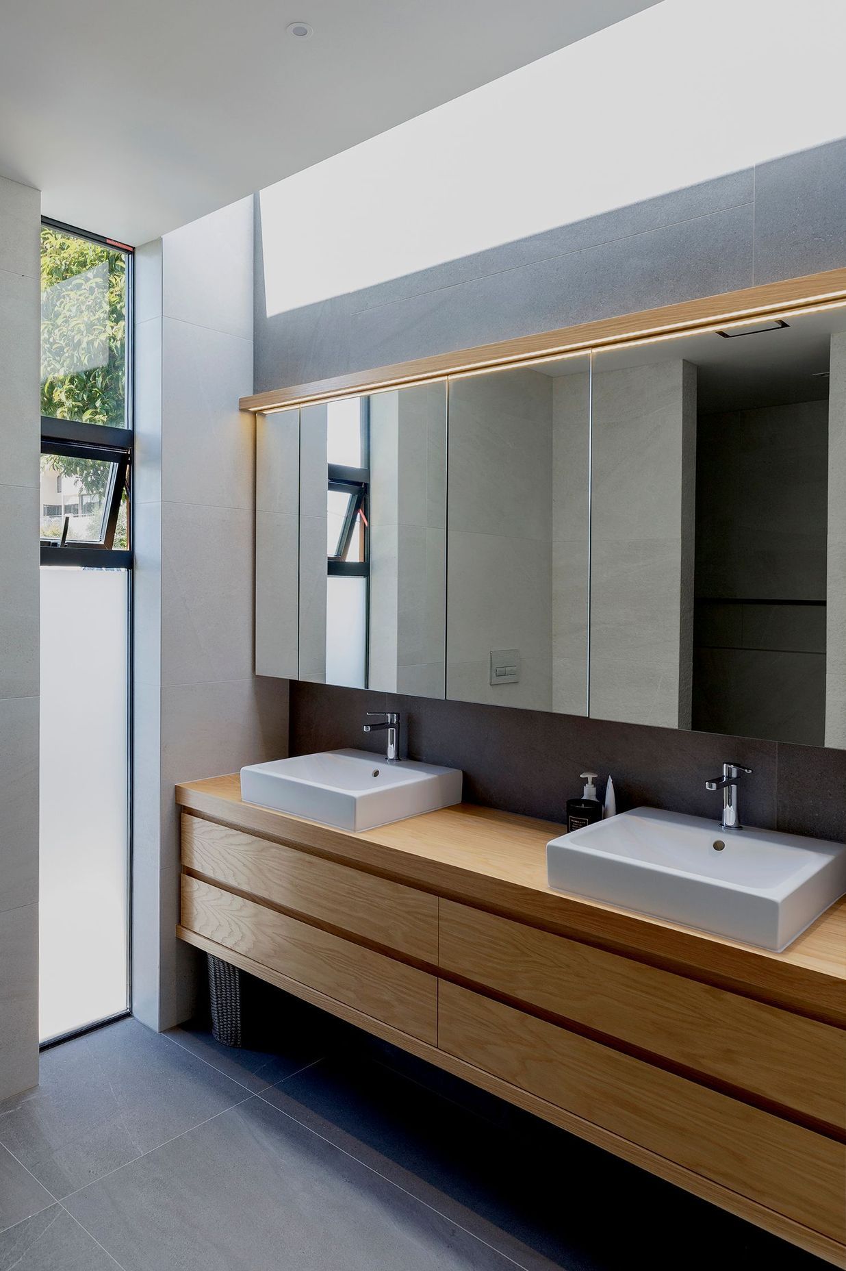 The bathroom features a clerestory window for extra light and robust basalt flooring tiles.