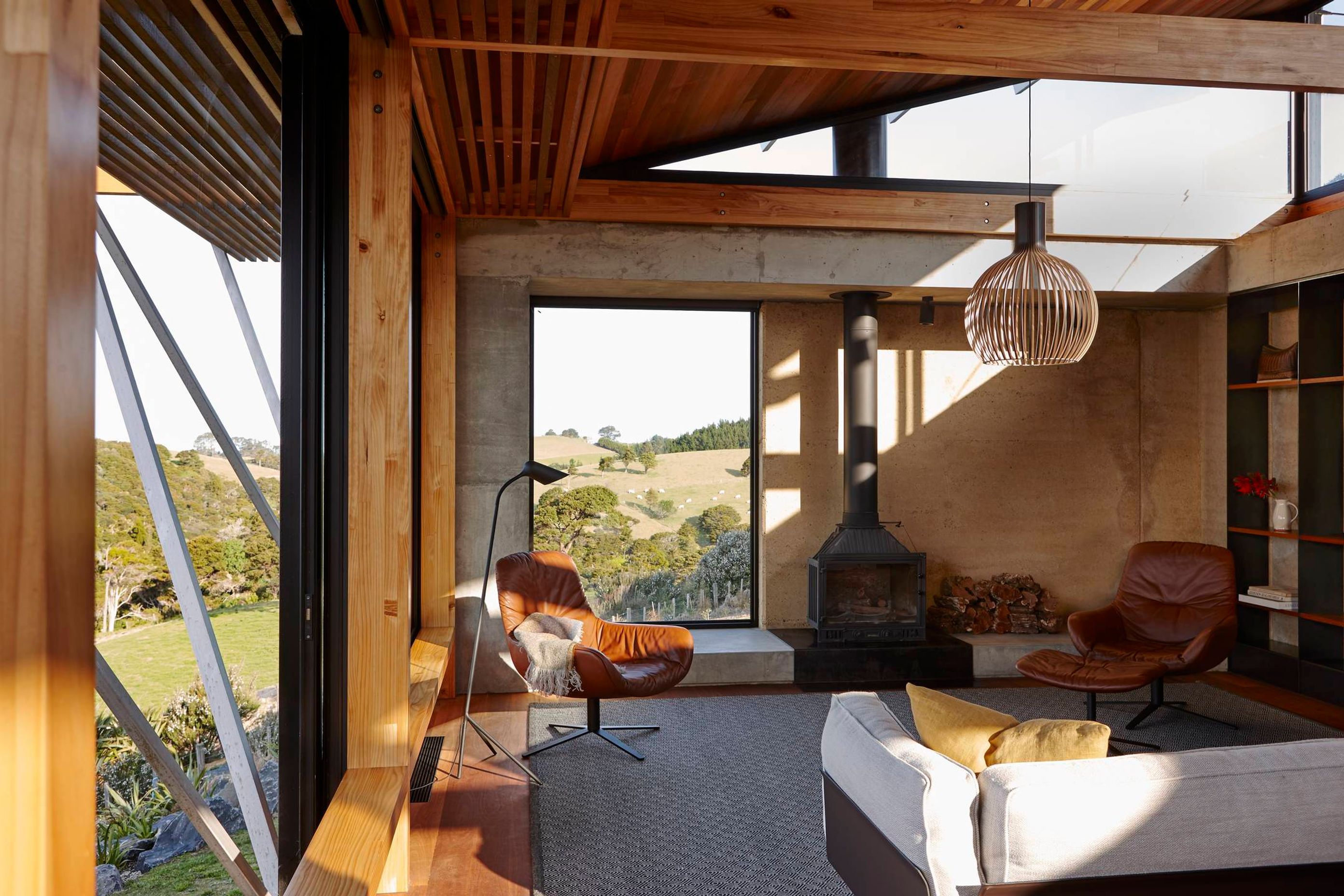The rammed earth wall is exposed on the interior of the lounge, adding a strong earthy contrast to the timber and glass. Photograph by Jackie Meiring.
