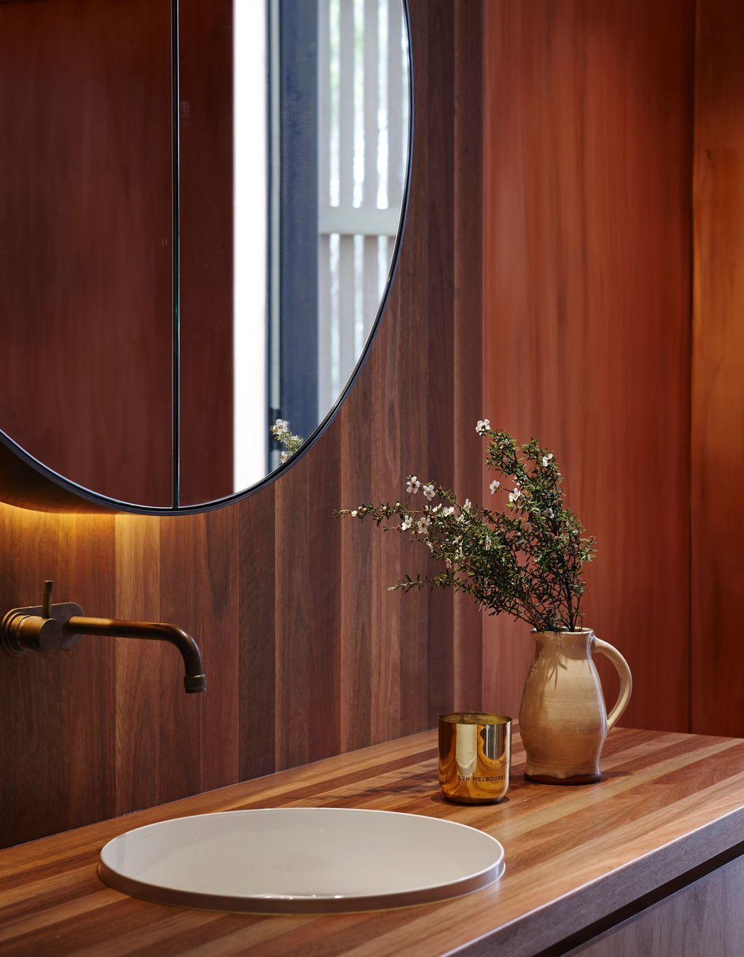 Copper tapware and bespoke timber cabinetry add yet more warmth into the bathrooms.