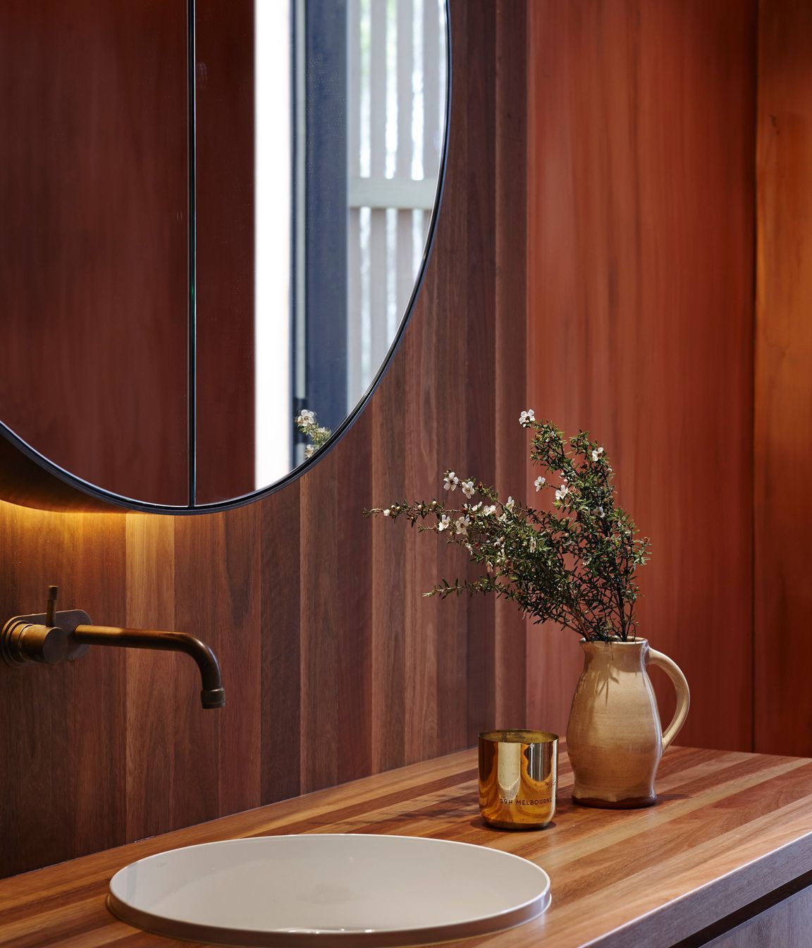 Copper tapware and bespoke timber cabinetry add yet more warmth into the bathrooms.