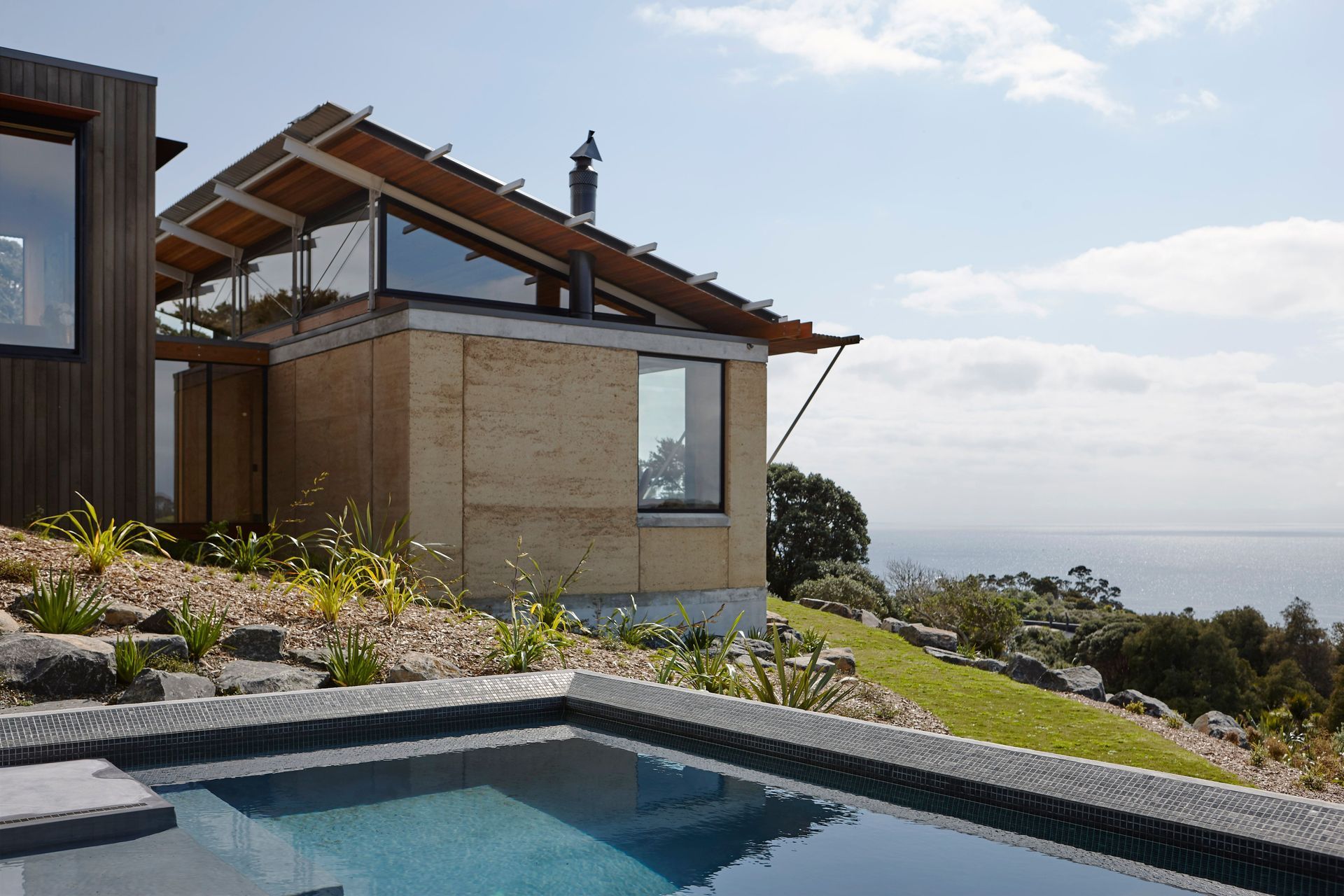 The roof pops up to draw more light into the interior. The teal-blue swimming pool matches the colour of the ocean and looks out to Poor Knights Islands. Photograph by Jackie Meiring.