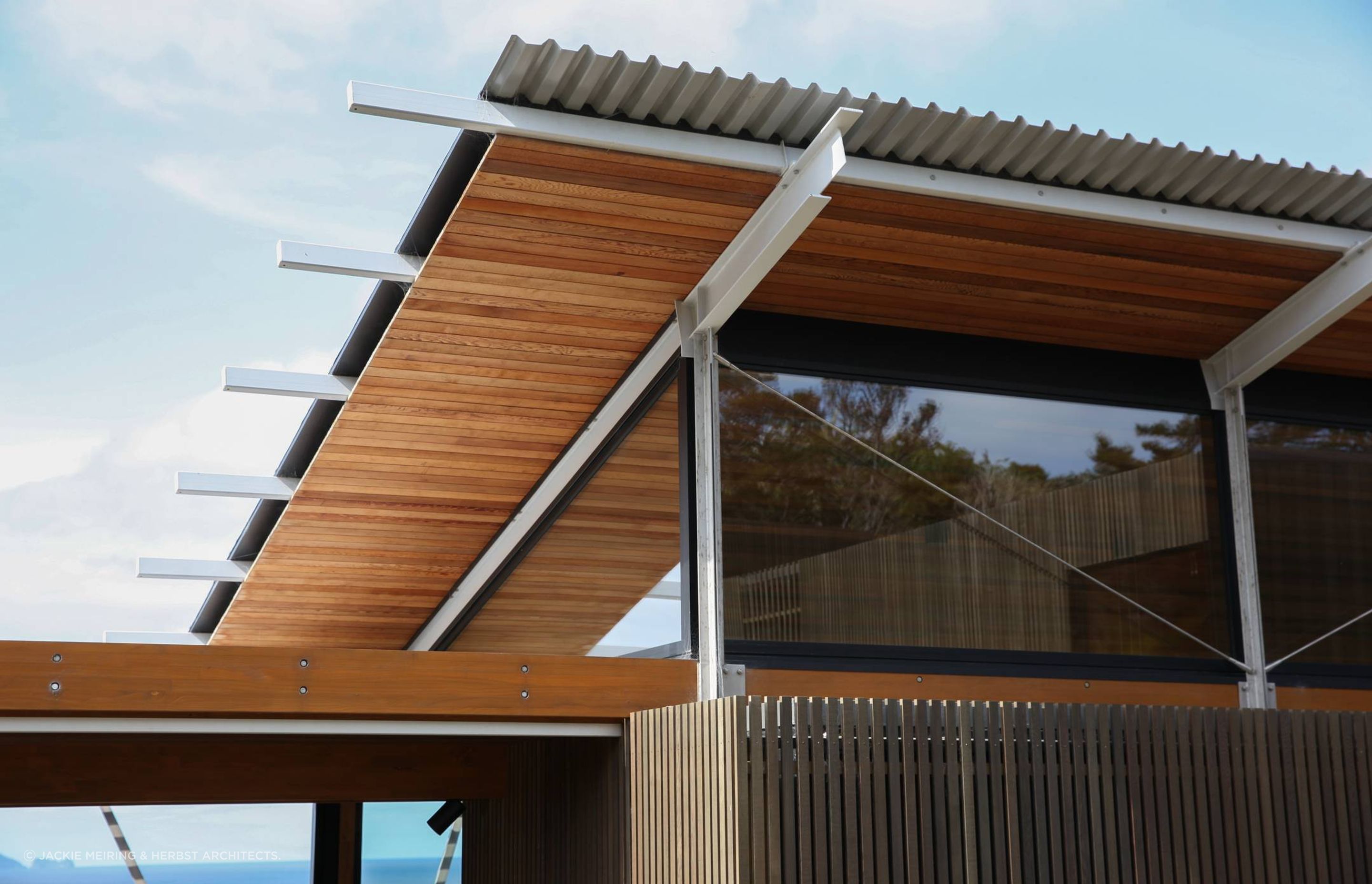 A detail showing the cedar-clad soffit and the steel structure with cable ties providing additional bracing.