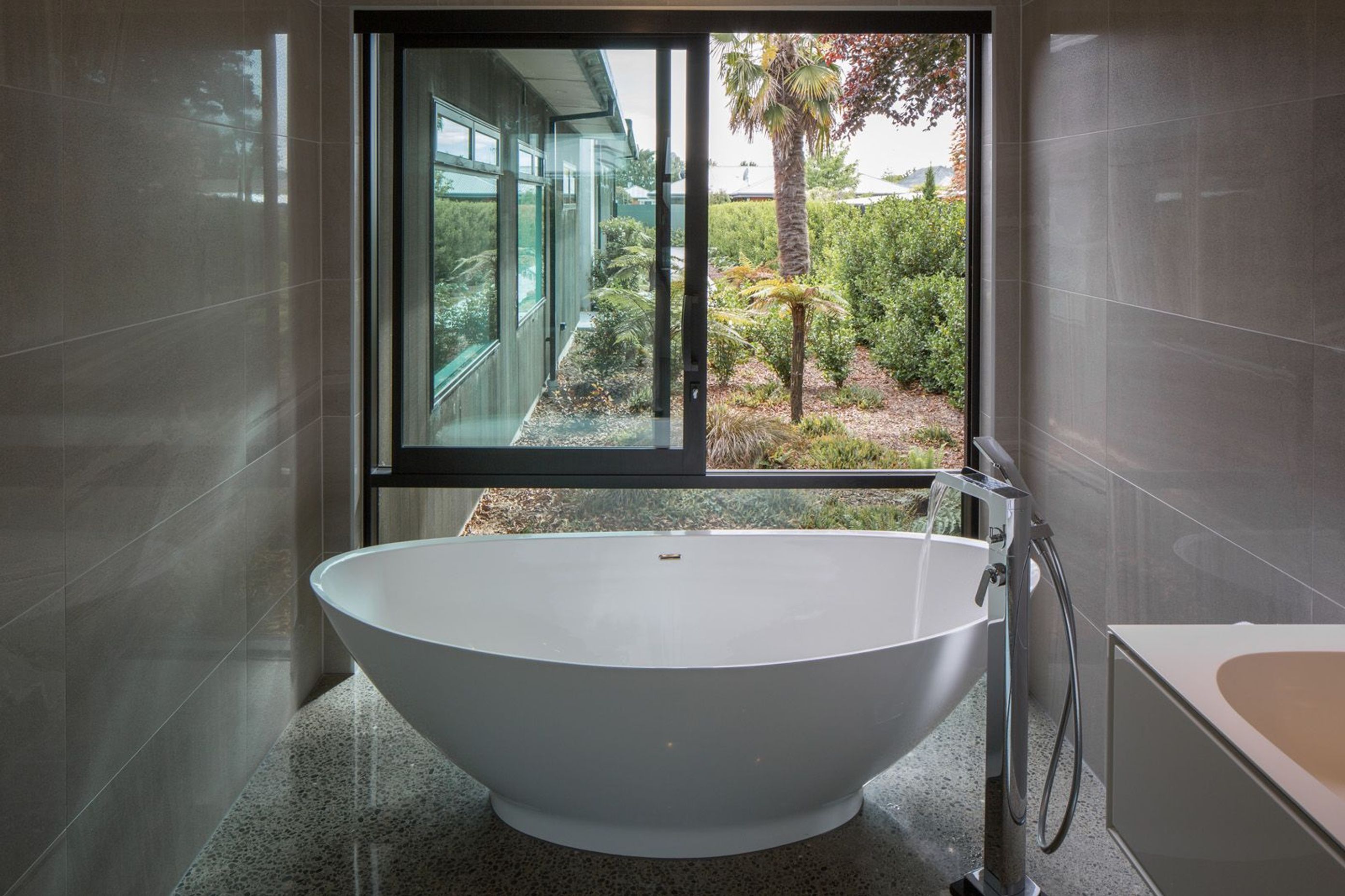 The master ensuite features floor-to-ceiling glazing, further enhancing the sense of connection to the garden.