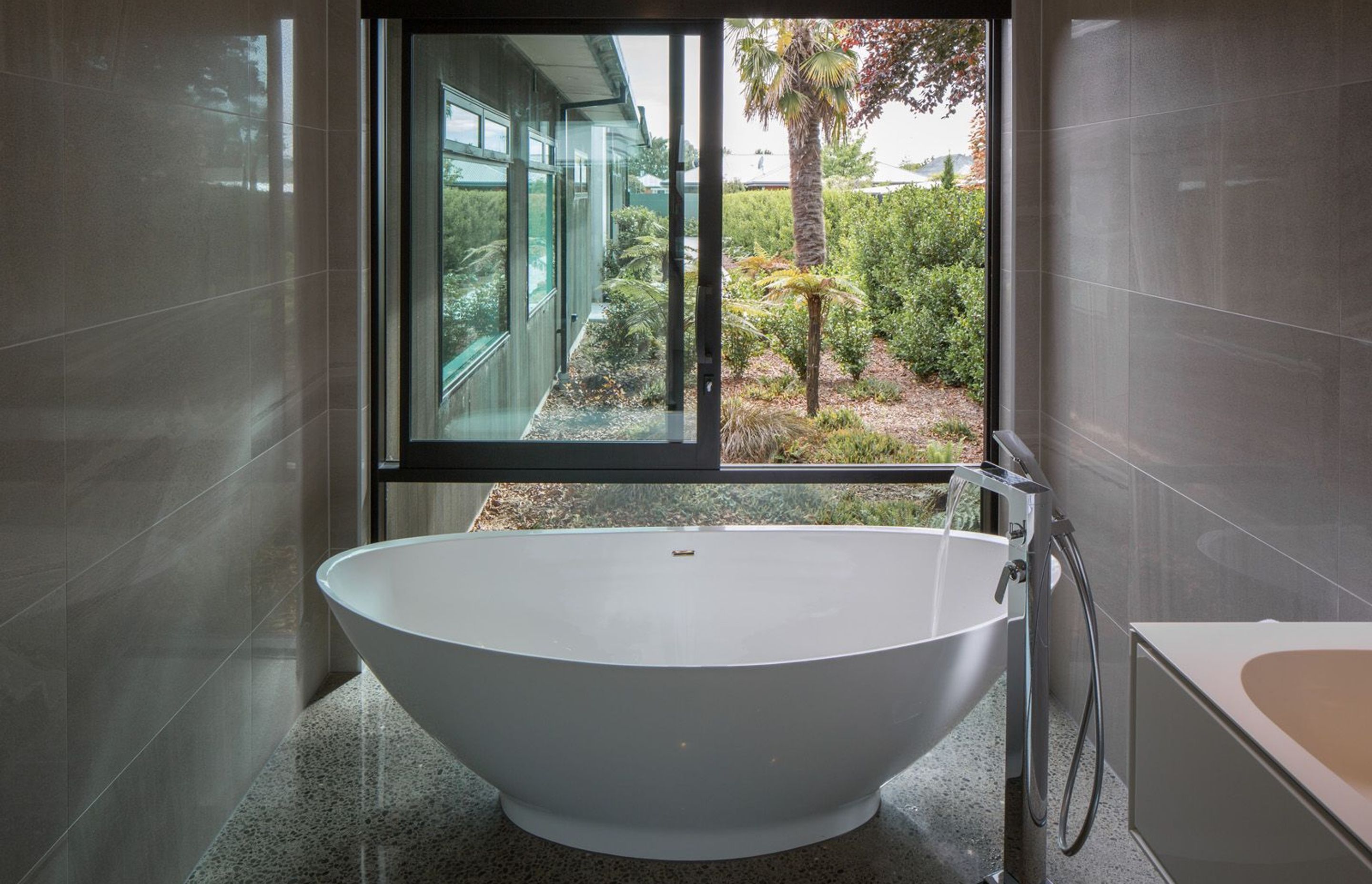 The master ensuite features floor-to-ceiling glazing, further enhancing the sense of connection to the garden.