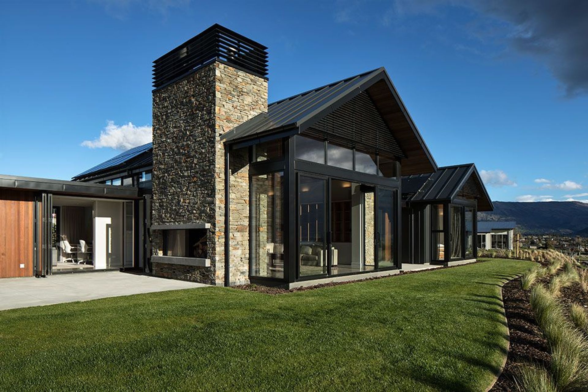 Setback, lower-profile linking elements between the gabled sections also create sheltered outdoor courtyards that provide for outdoor living in any weather.