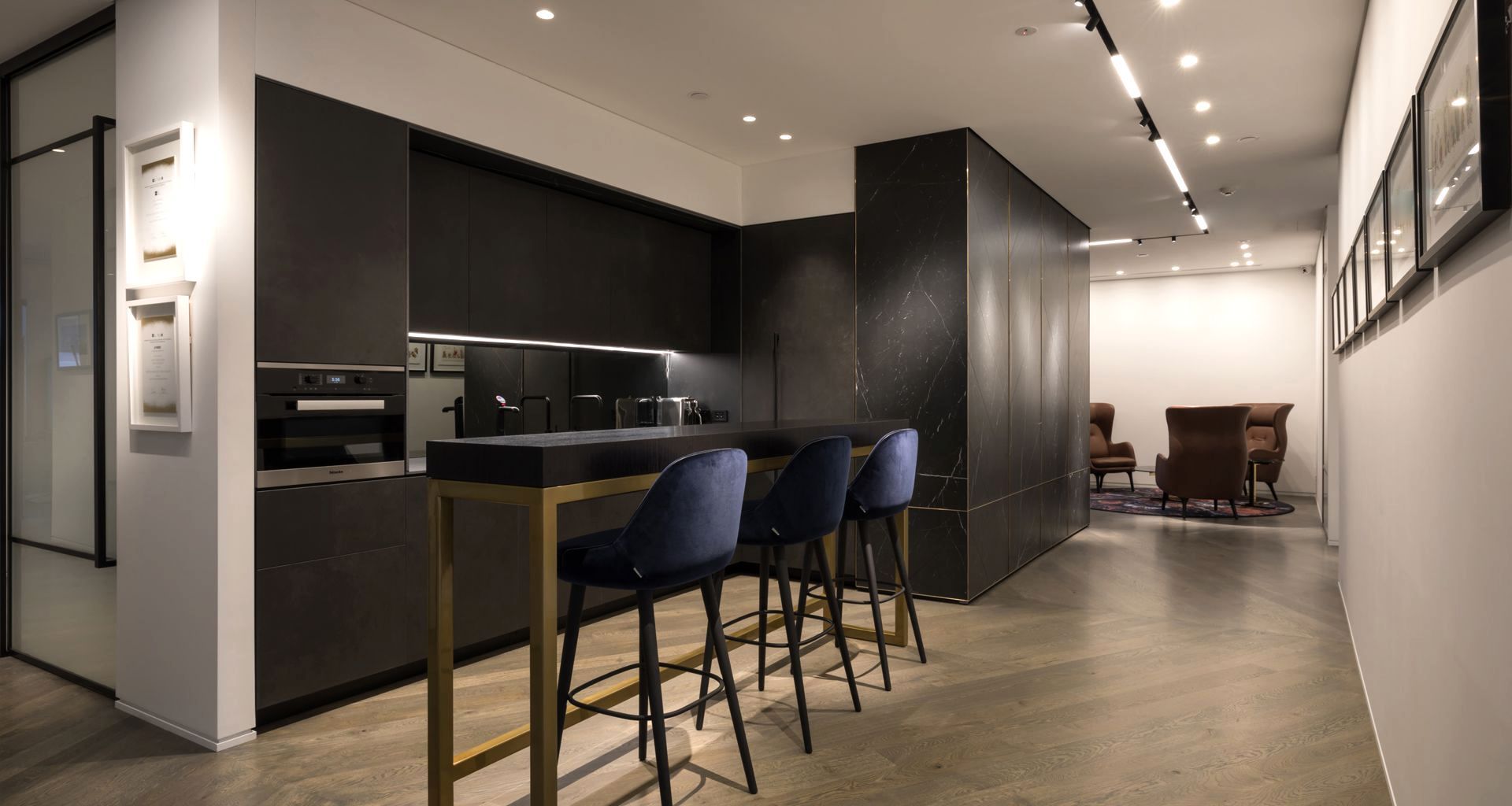 Bespoke kitchen, view past herringbone stone wall with brass inlay, towards reception lounge