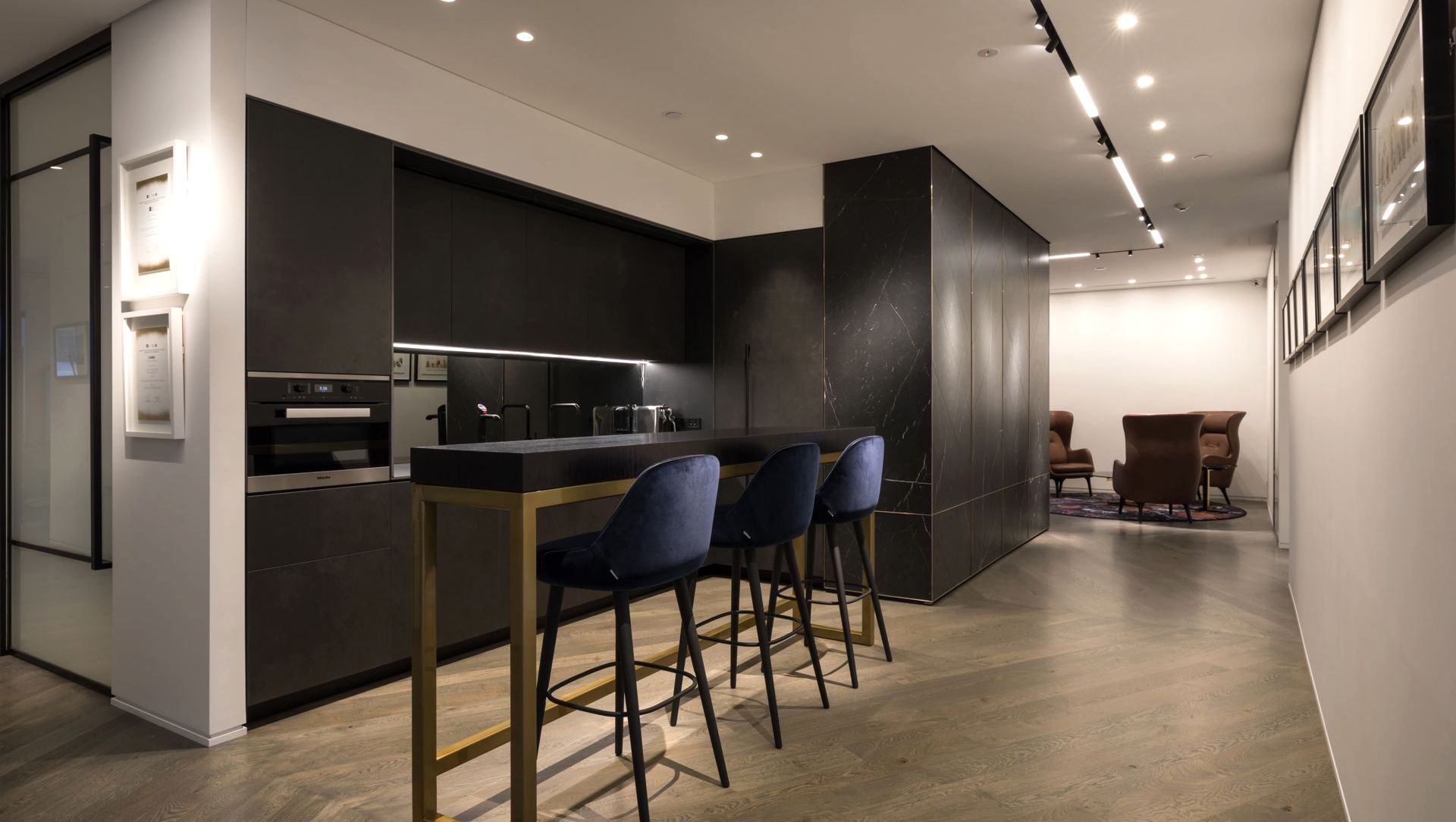 Bespoke kitchen, view past herringbone stone wall with brass inlay, towards reception lounge