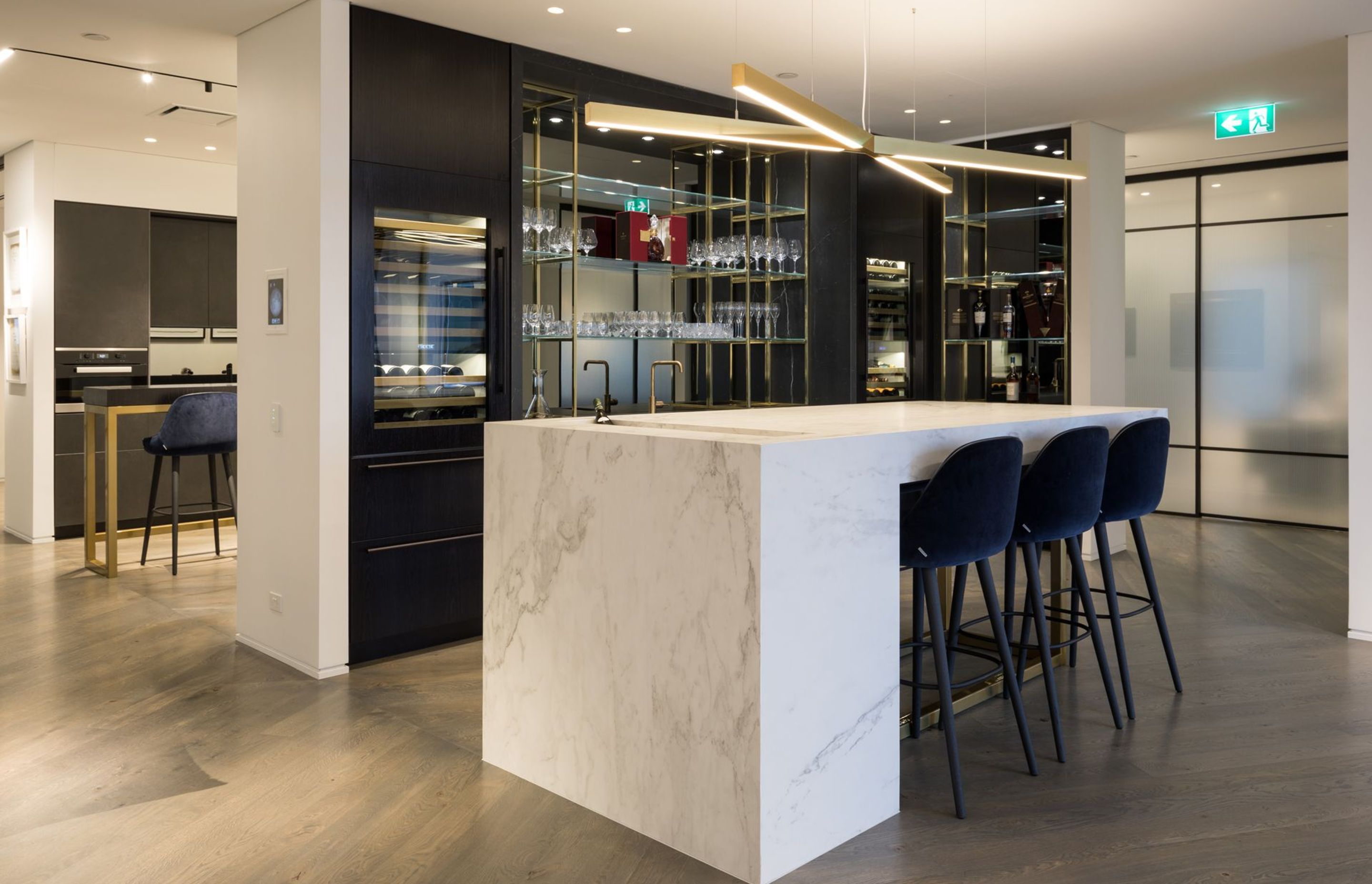 Cantilered stone bar with seamless sunken ice bucket, bespoke shelving in entertain/meet area