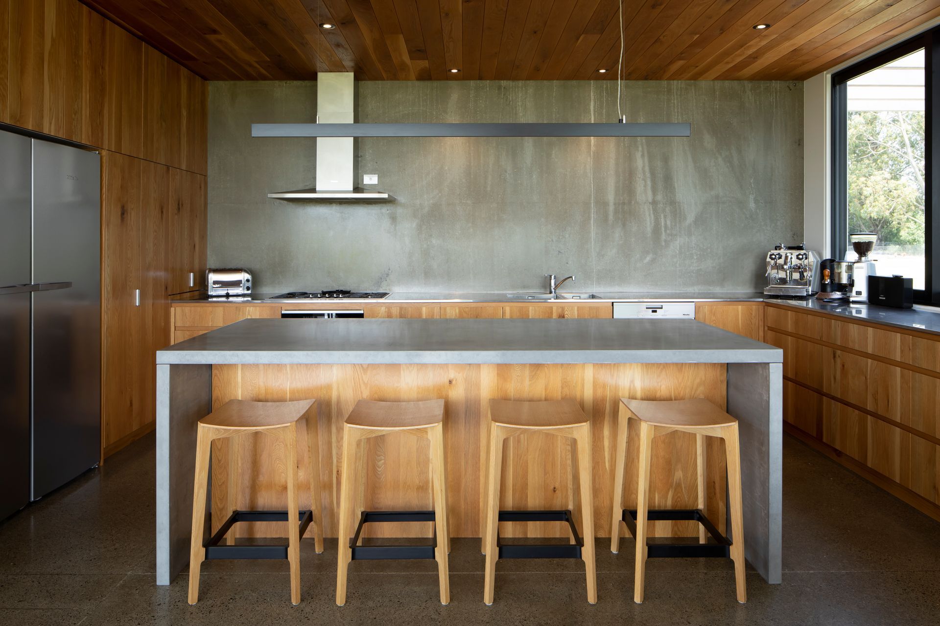 The lower ceiling height of the oak and concrete kitchen creates an intimate feeling within the space.