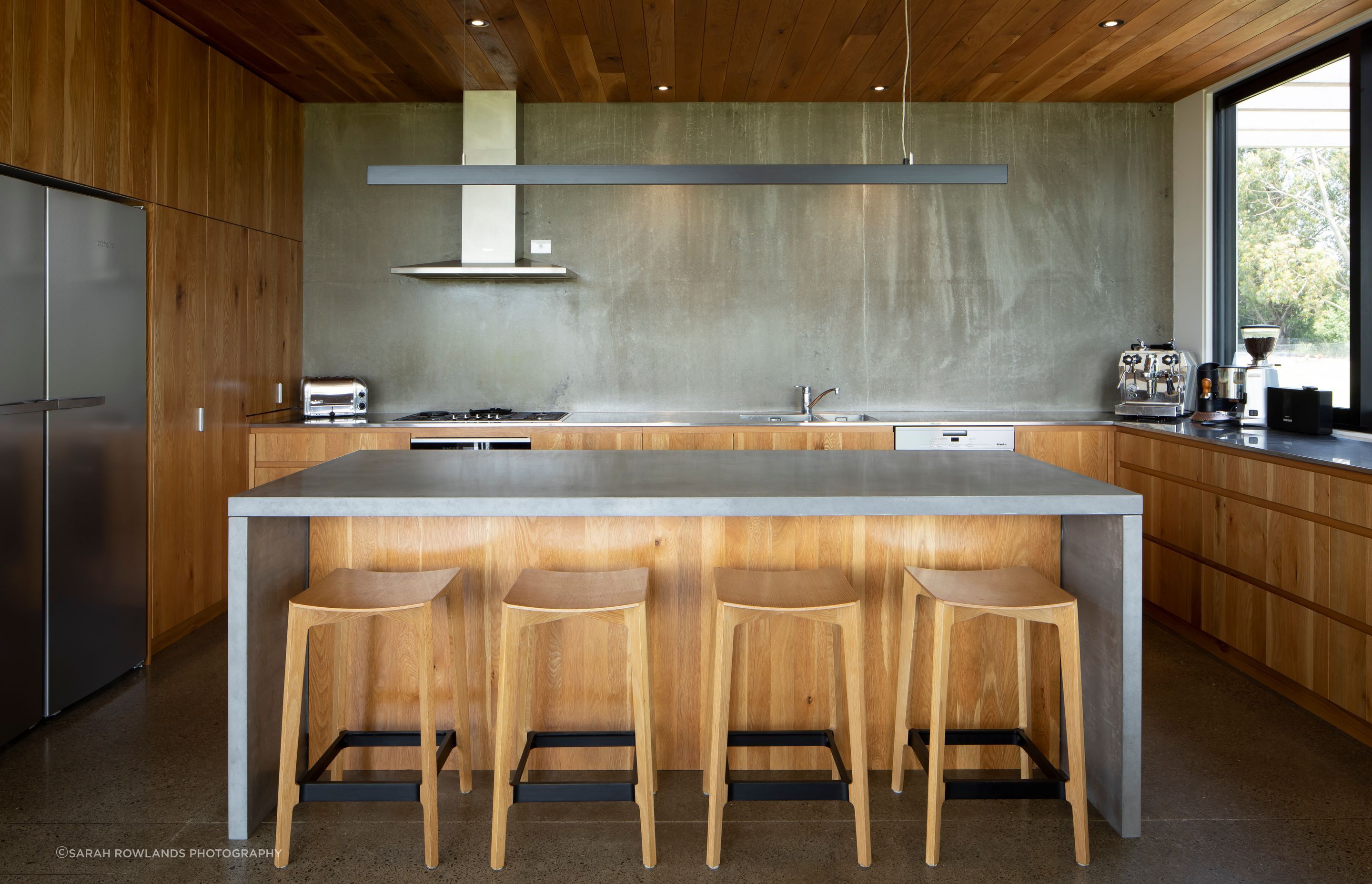 The lower ceiling height of the oak and concrete kitchen creates an intimate feeling within the space.