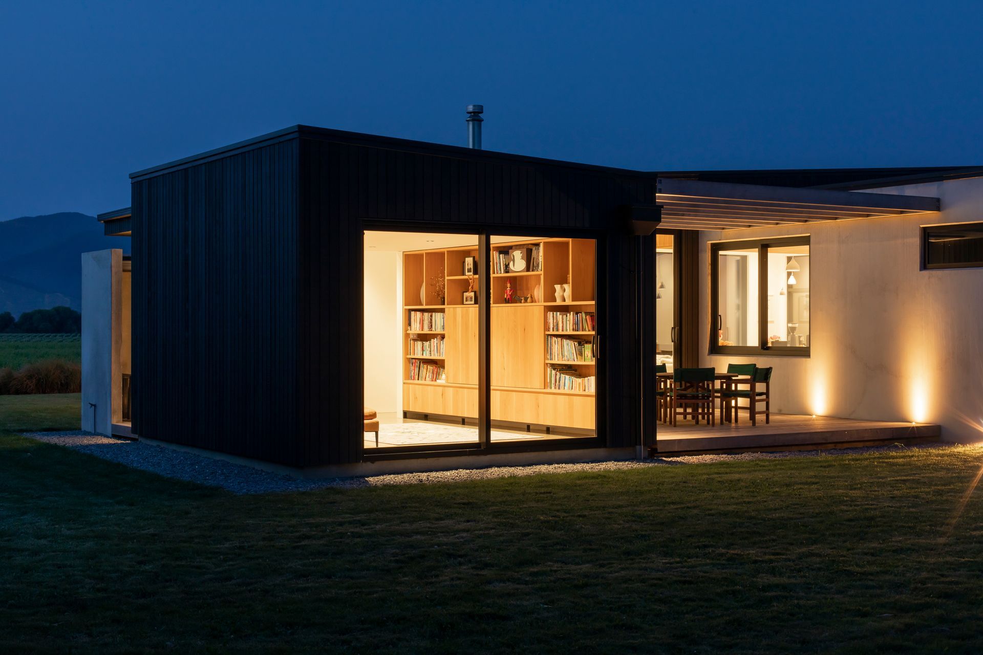 A small sitting room offers a private space off the open-plan living area, while the courtyard shelters from the prevailing winds yet stays connected to the valley views thanks to floor-to-ceiling glazing.