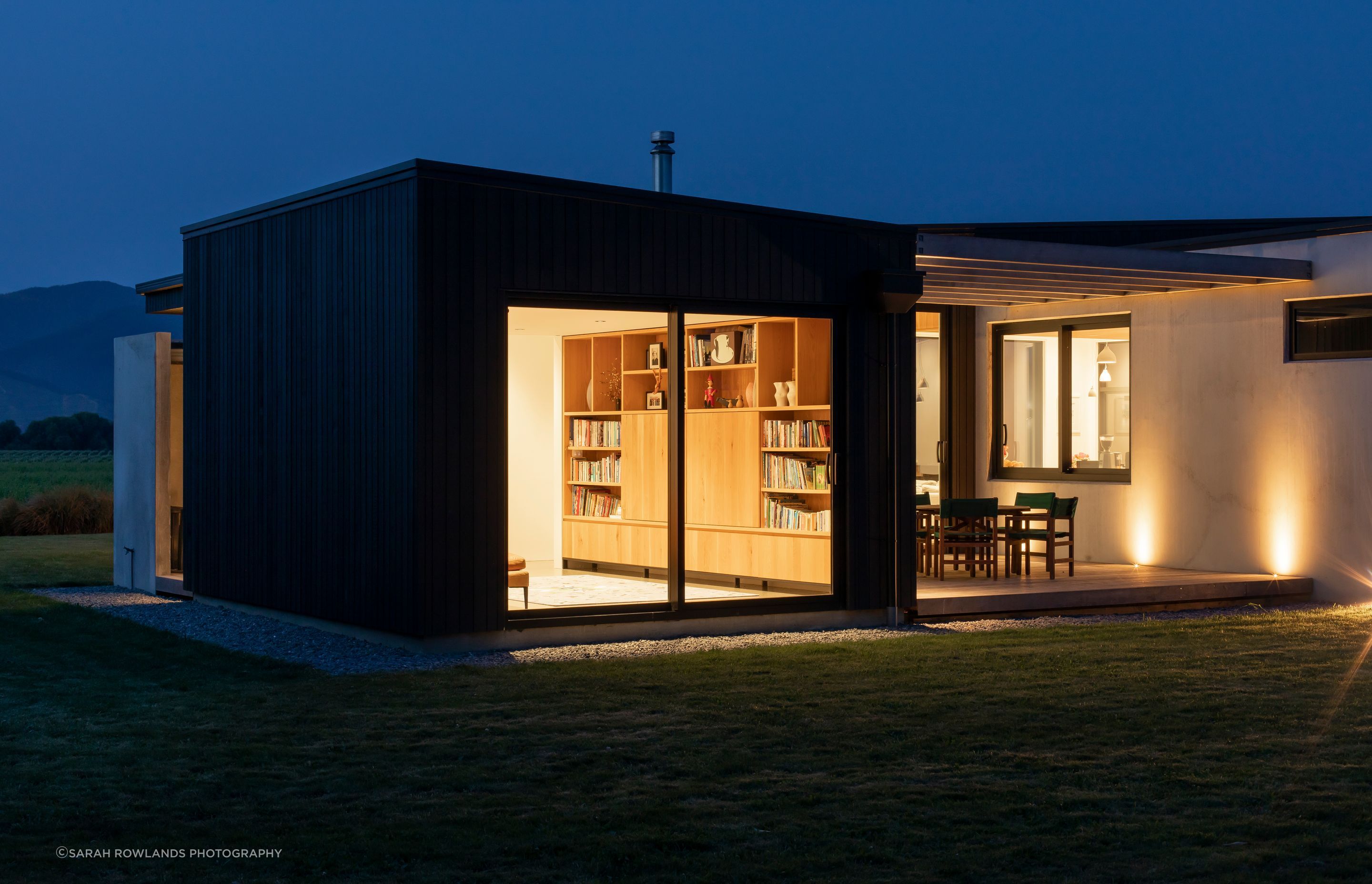 A small sitting room offers a private space off the open-plan living area, while the courtyard shelters from the prevailing winds yet stays connected to the valley views thanks to floor-to-ceiling glazing.