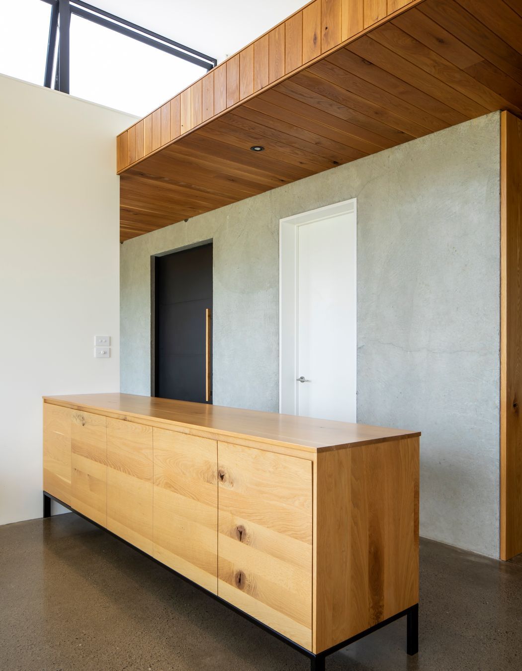 The oak-lined ceiling follows the height established in the entrance area.