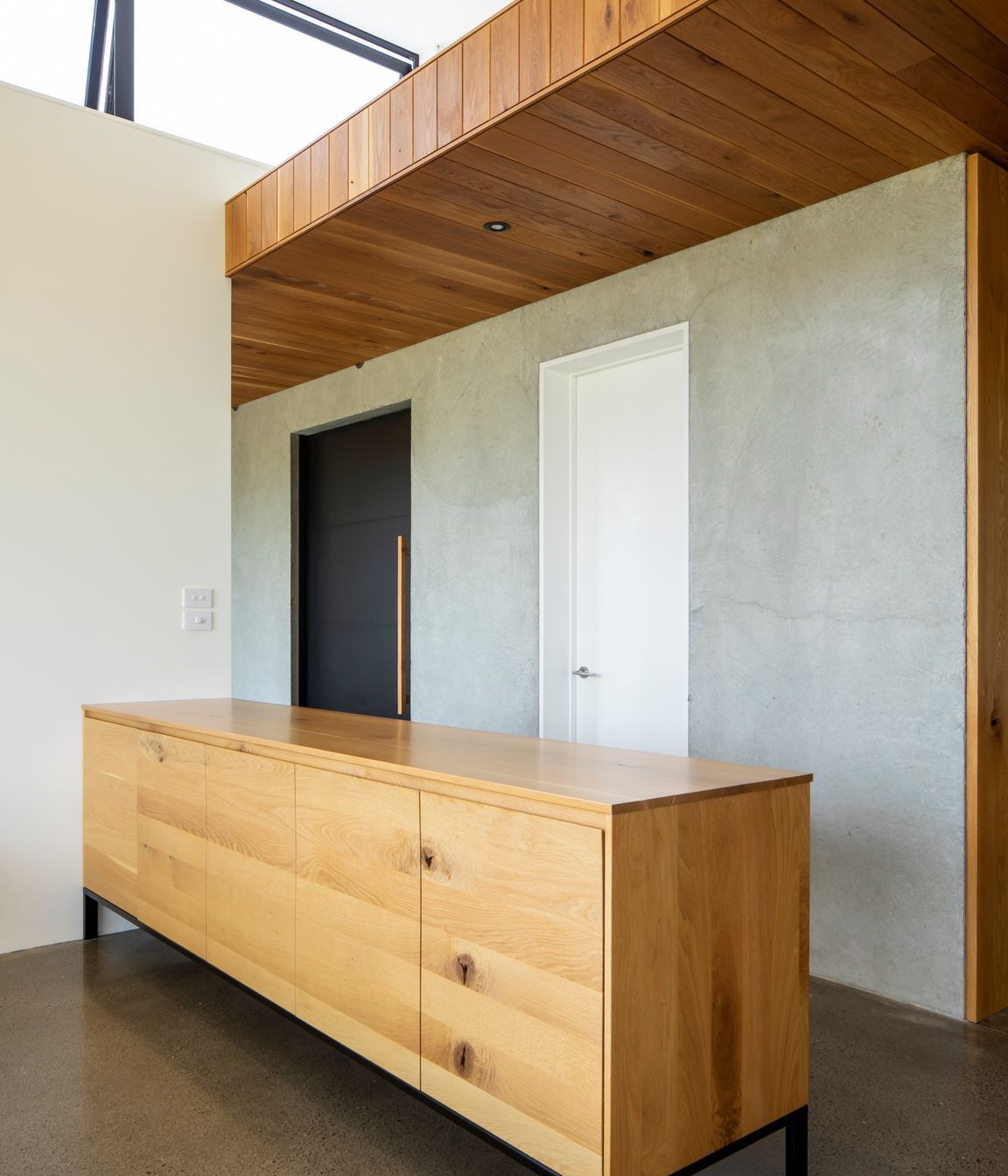 The oak-lined ceiling follows the height established in the entrance area.