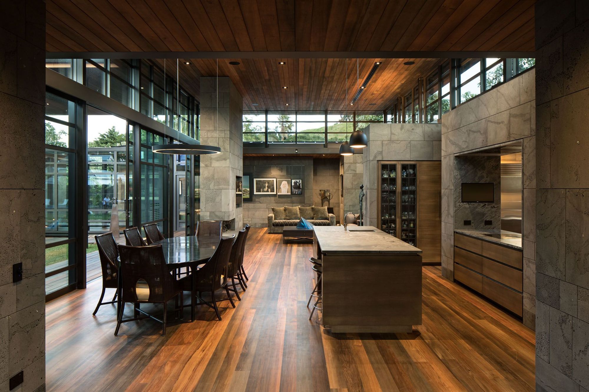 The dining and kitchen areas. Totara riverwood lines the ceilings throughout the main living spaces and rimu riverwood creates a stunning varied pattern on the floor.