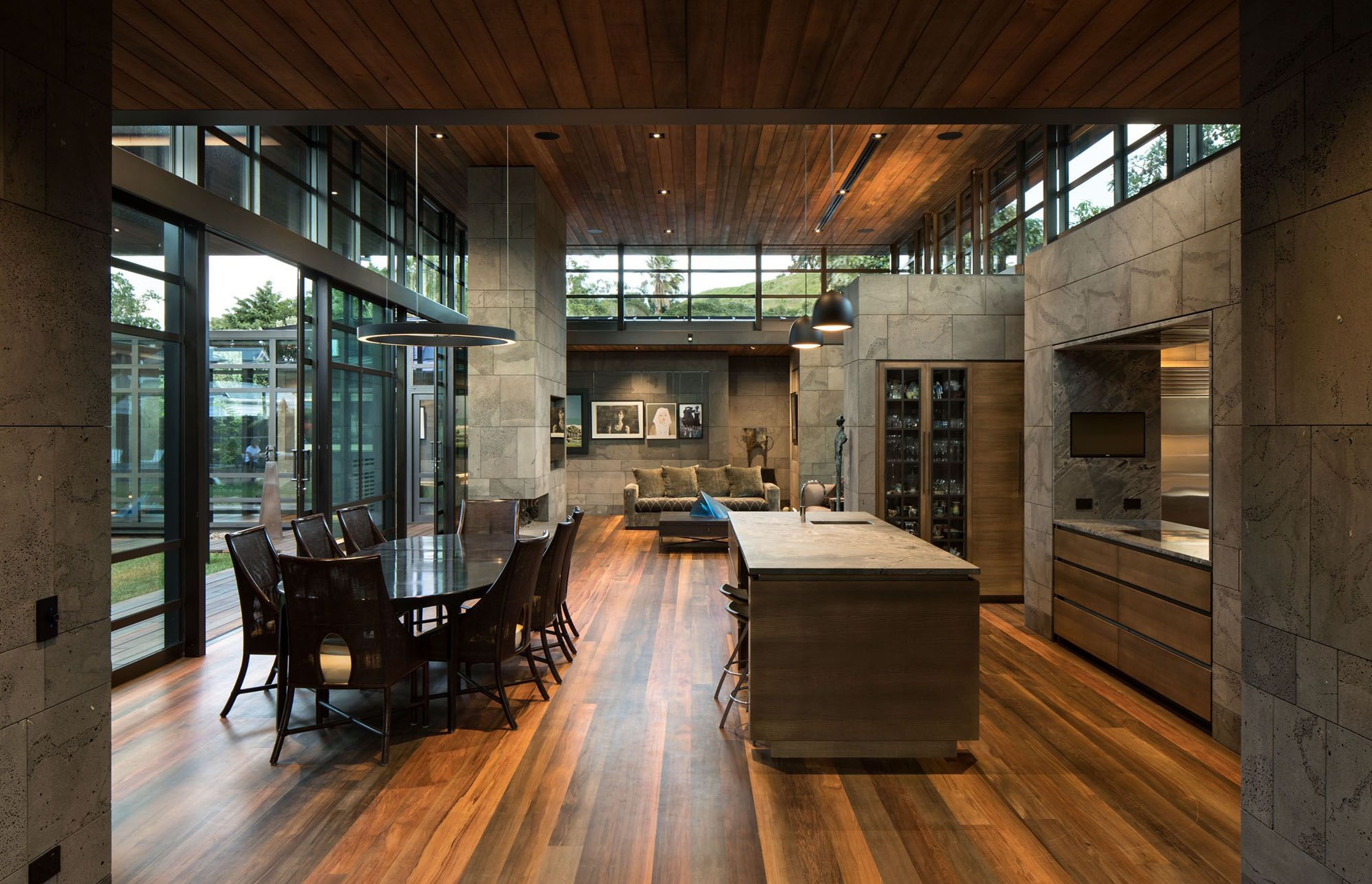 The dining and kitchen areas. Totara riverwood lines the ceilings throughout the main living spaces and rimu riverwood creates a stunning varied pattern on the floor.