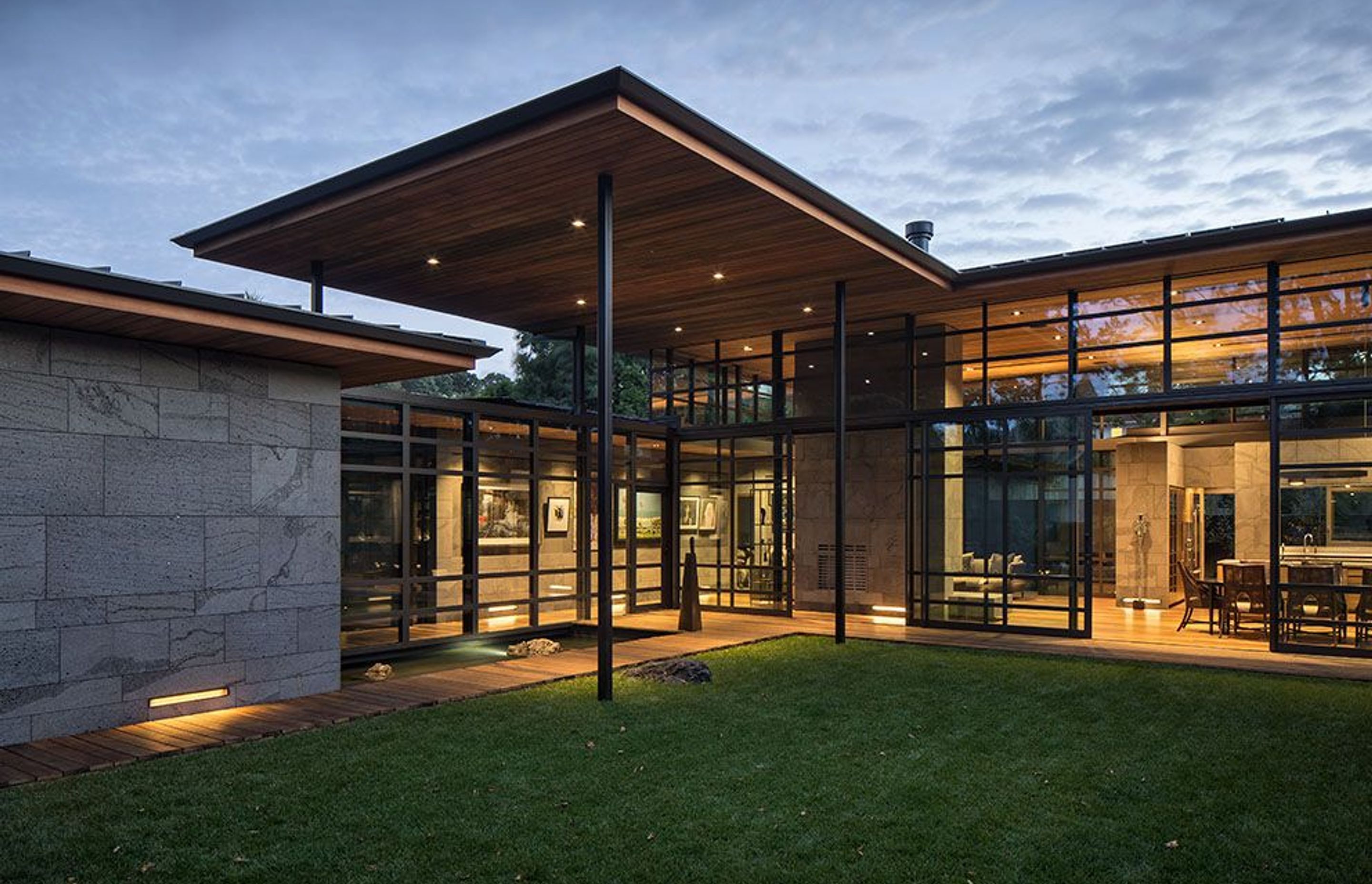 Surrounding the central courtyard (left to right) is the garage and its entry corridor, the main entryway with cantilevered roof overhang and the open-plan living/kitchen/dining space. 