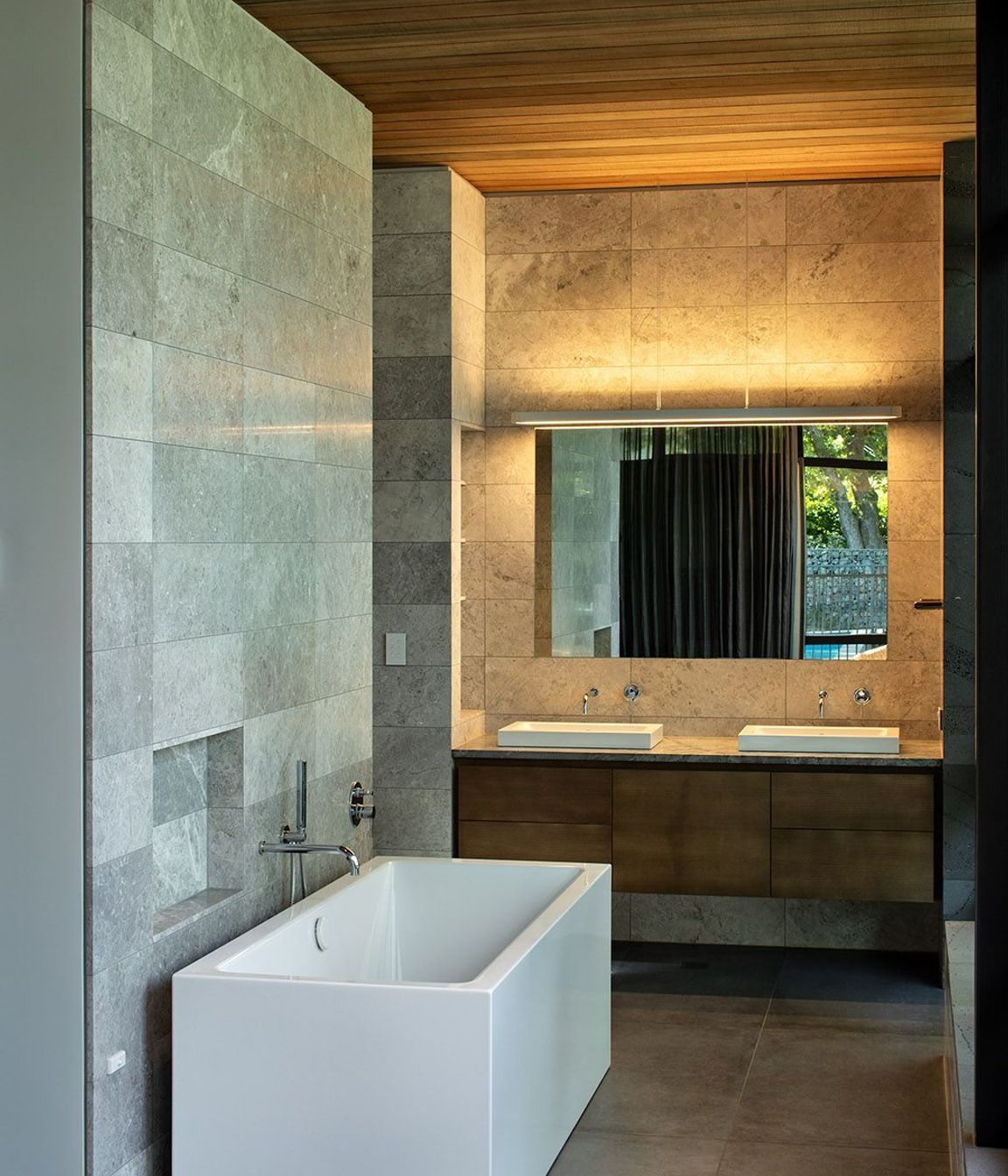 The bathrooms are lined in stone and timber to complement the rest of the house.