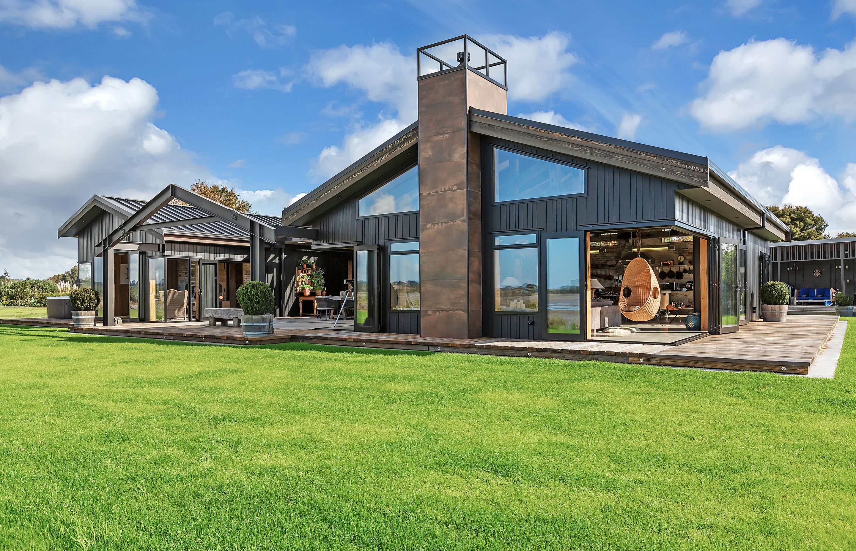 A pair of gabled forms bookend a central courtyard. Durable cladding was specified to mitigrate the effects of being sited within a coastal environment.