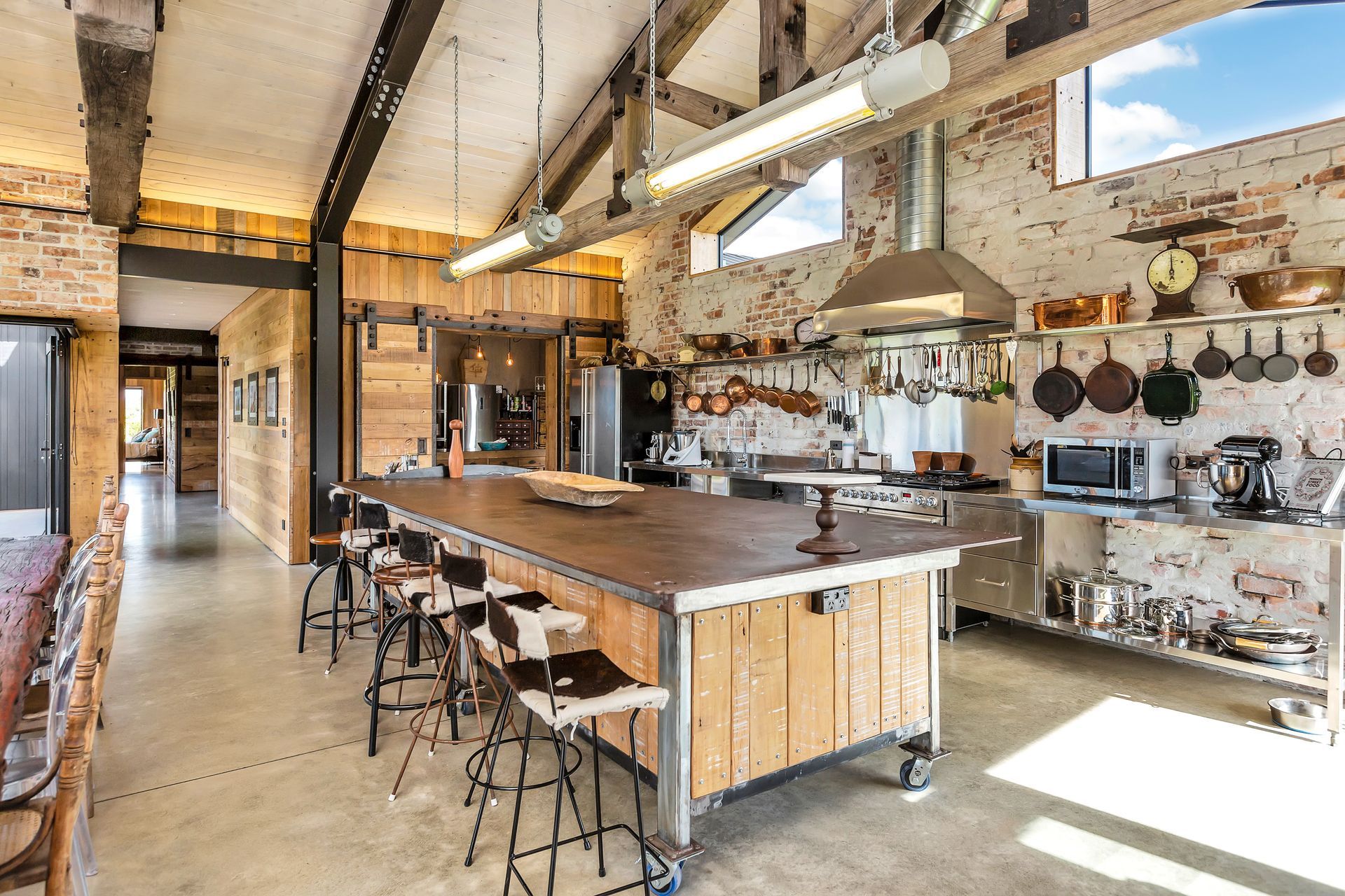 The kitchen is designing to be hard-wearing and highly functional with open shelving and accessible equipment. The recycled solid steel engineers' workbench is from Nelson