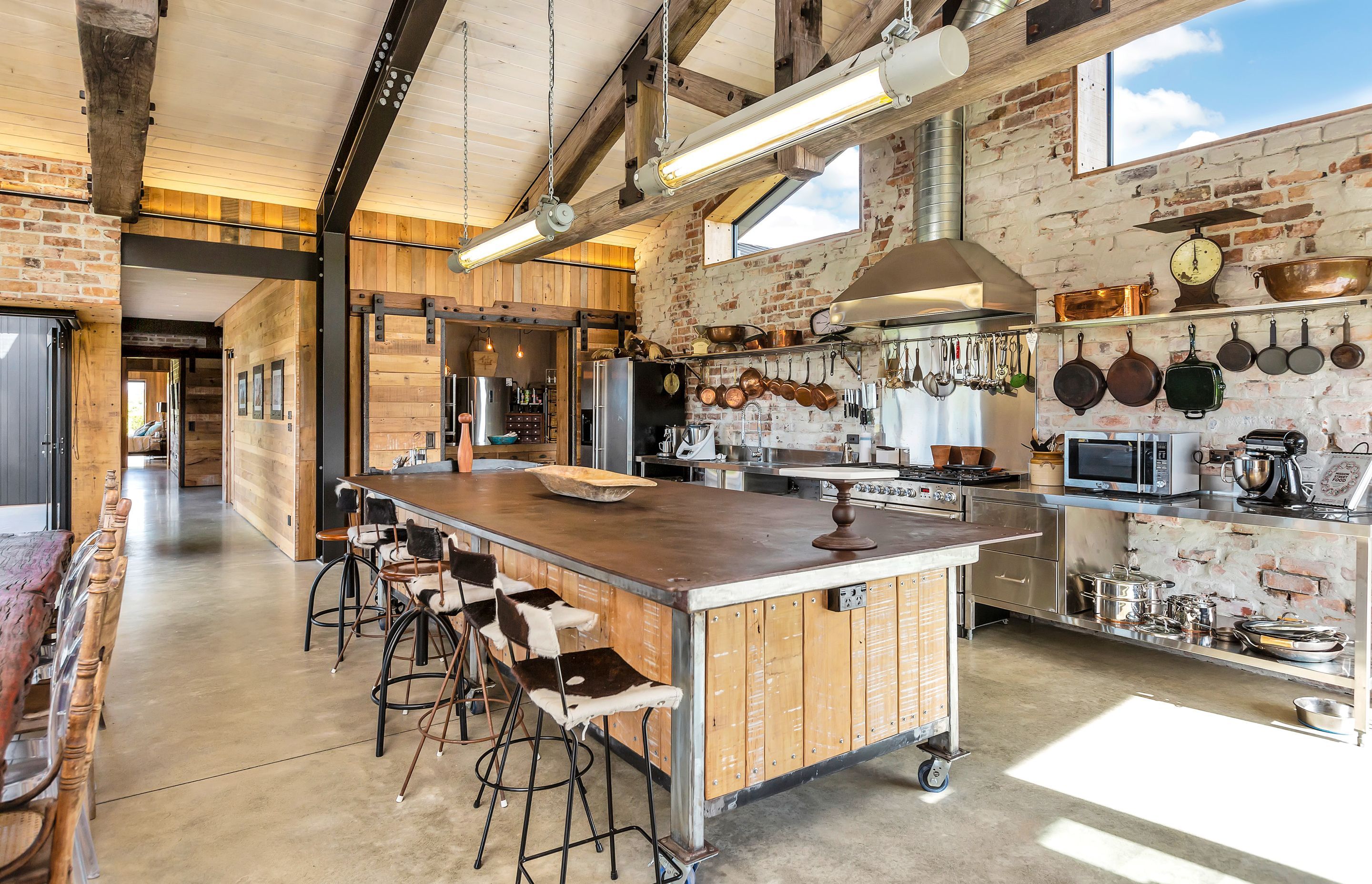 The kitchen is designing to be hard-wearing and highly functional with open shelving and accessible equipment. The recycled solid steel engineers' workbench is from Nelson