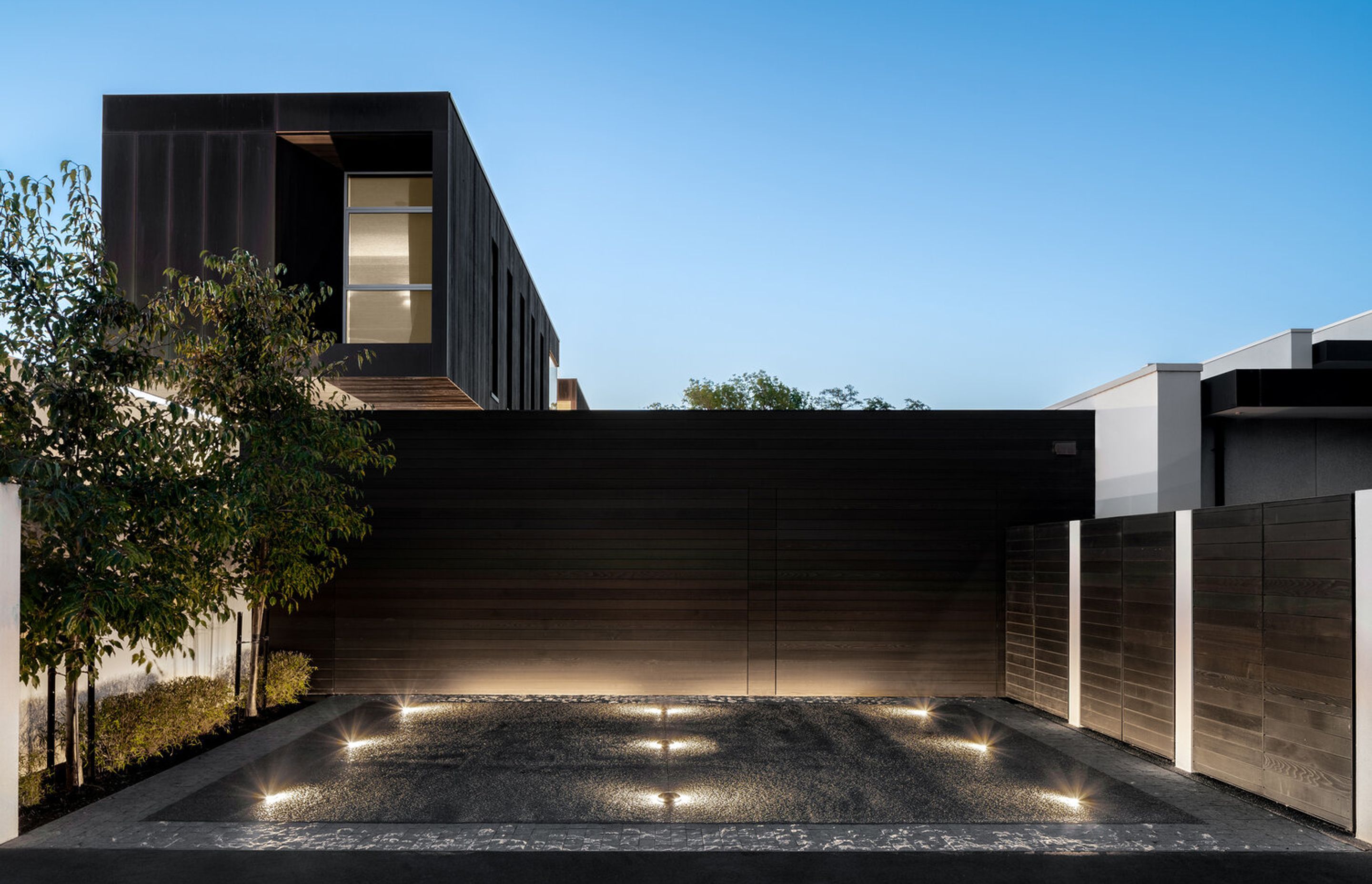 Garaging is seamlessly integrated into the structure behind cedar cladding.