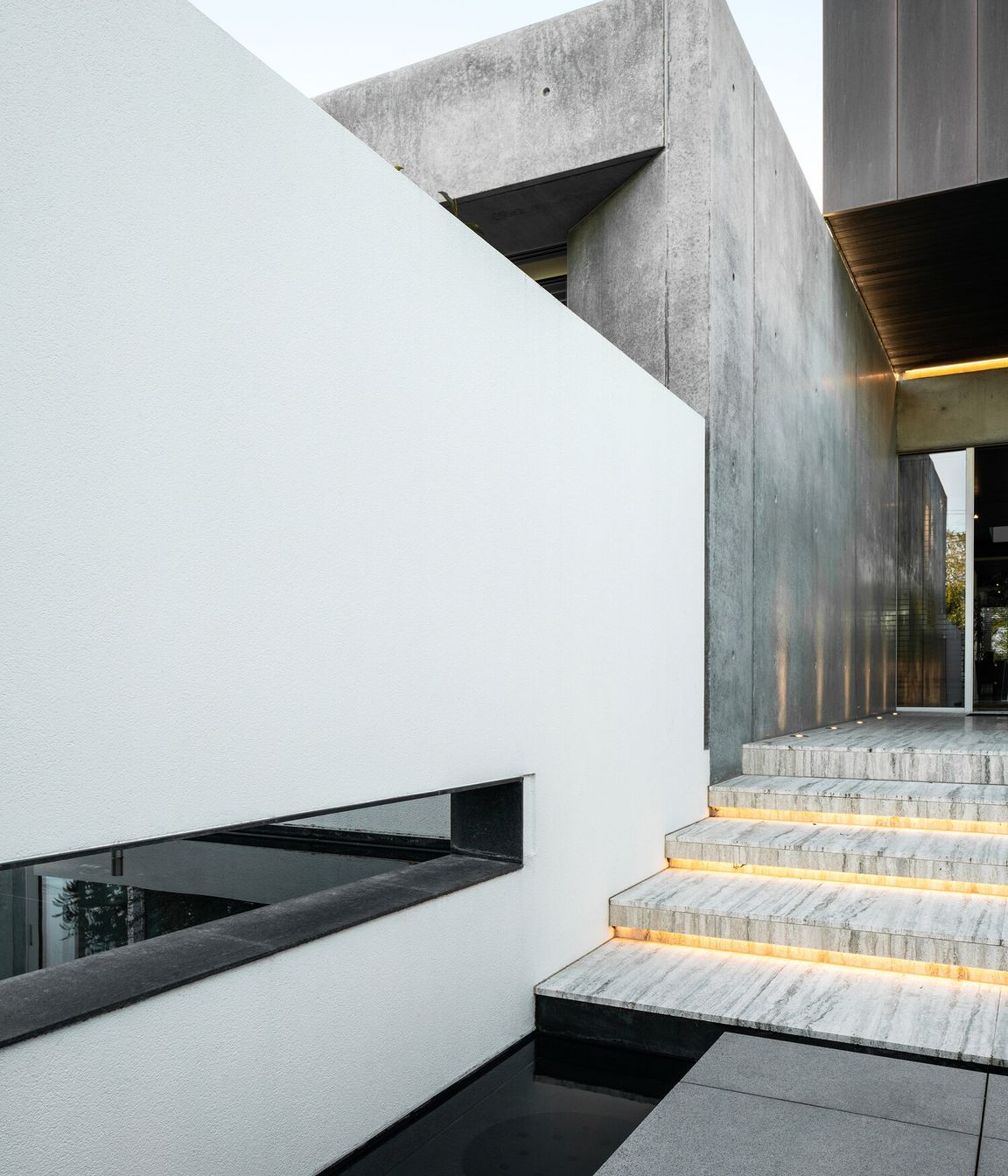 Copper and travertine surfaces are dressed between expressed structural elements of concrete and steel to create an enduring, timeless home.