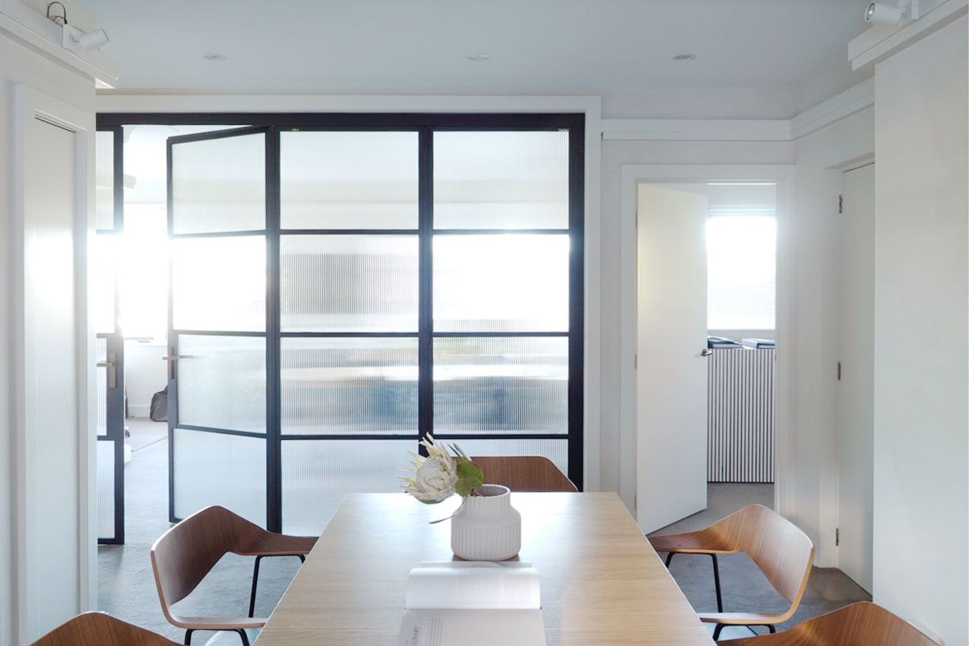 The meeting or dining table is centraly placed in the project. Metal Crittall bi fold doors open up the space further as need. Perfectly suited to this hostric building.
