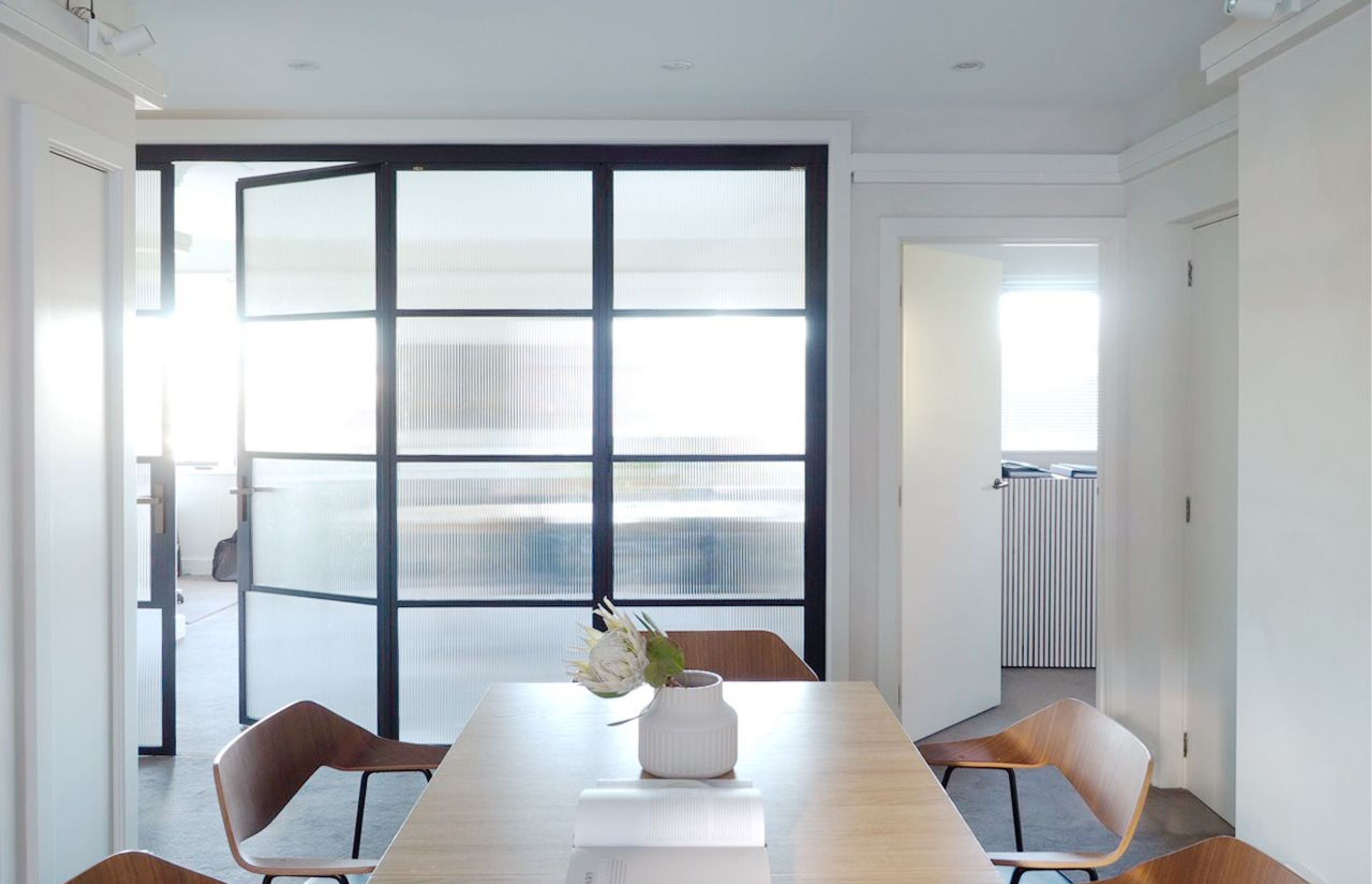 The meeting or dining table is centraly placed in the project. Metal Crittall bi fold doors open up the space further as need. Perfectly suited to this hostric building.