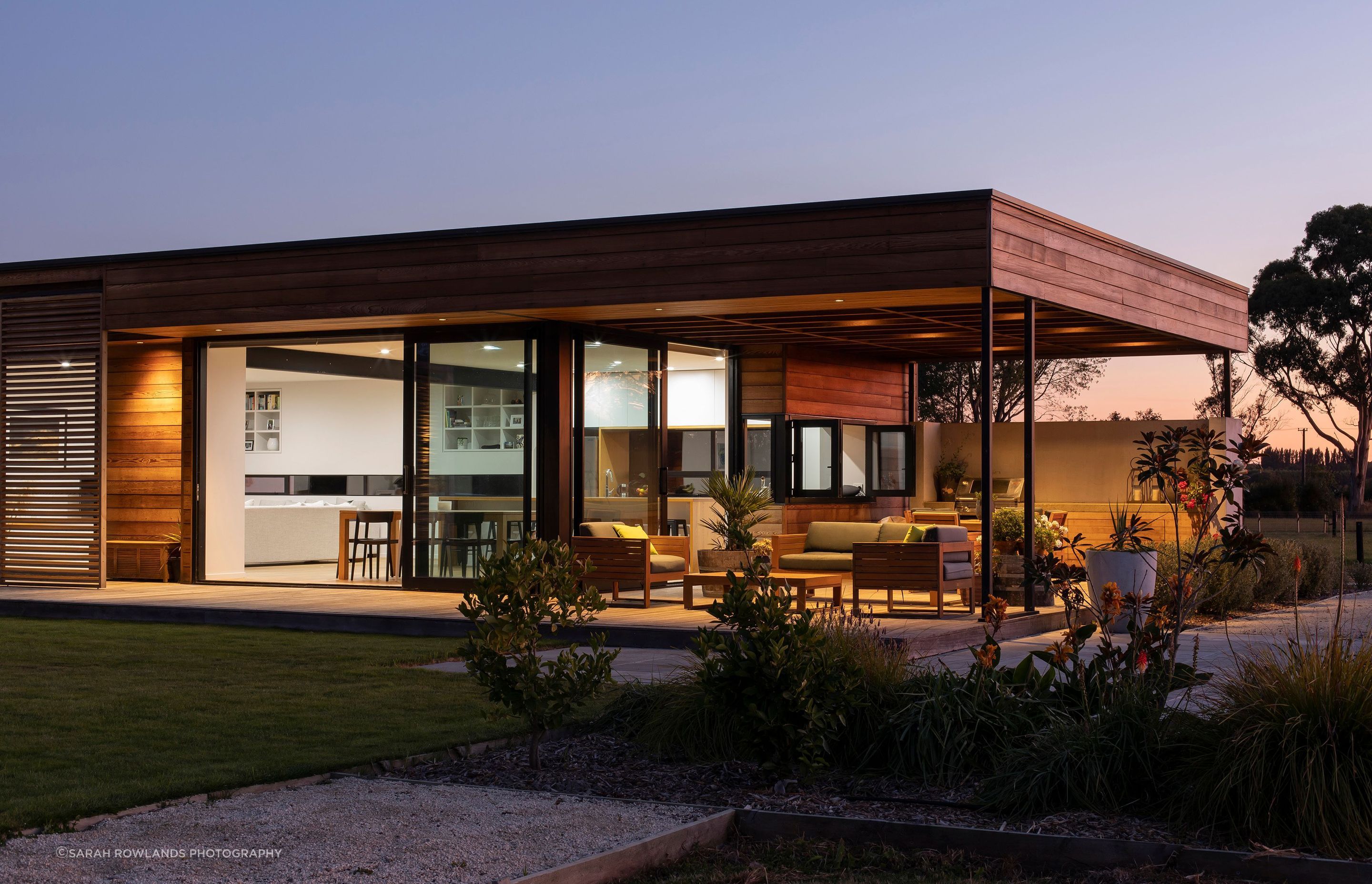 The outdoor room faces north and northwest and leads into the open-plan kitchen, dining and lounge areas. At the rear of the outdoor room is a built-in BBQ and outdoor dining table.