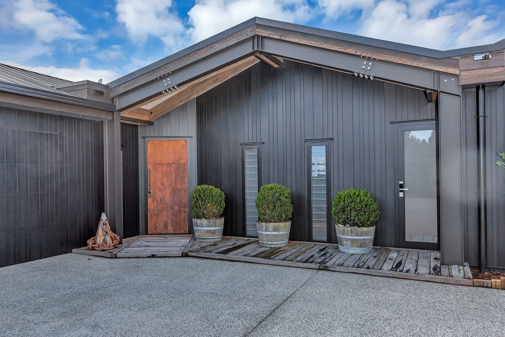 The main entrance provides a taster of the crafted interior, with its strking brass front door and recycled Tasmanian ironbark timber from the old Wellington tug boat wharf.