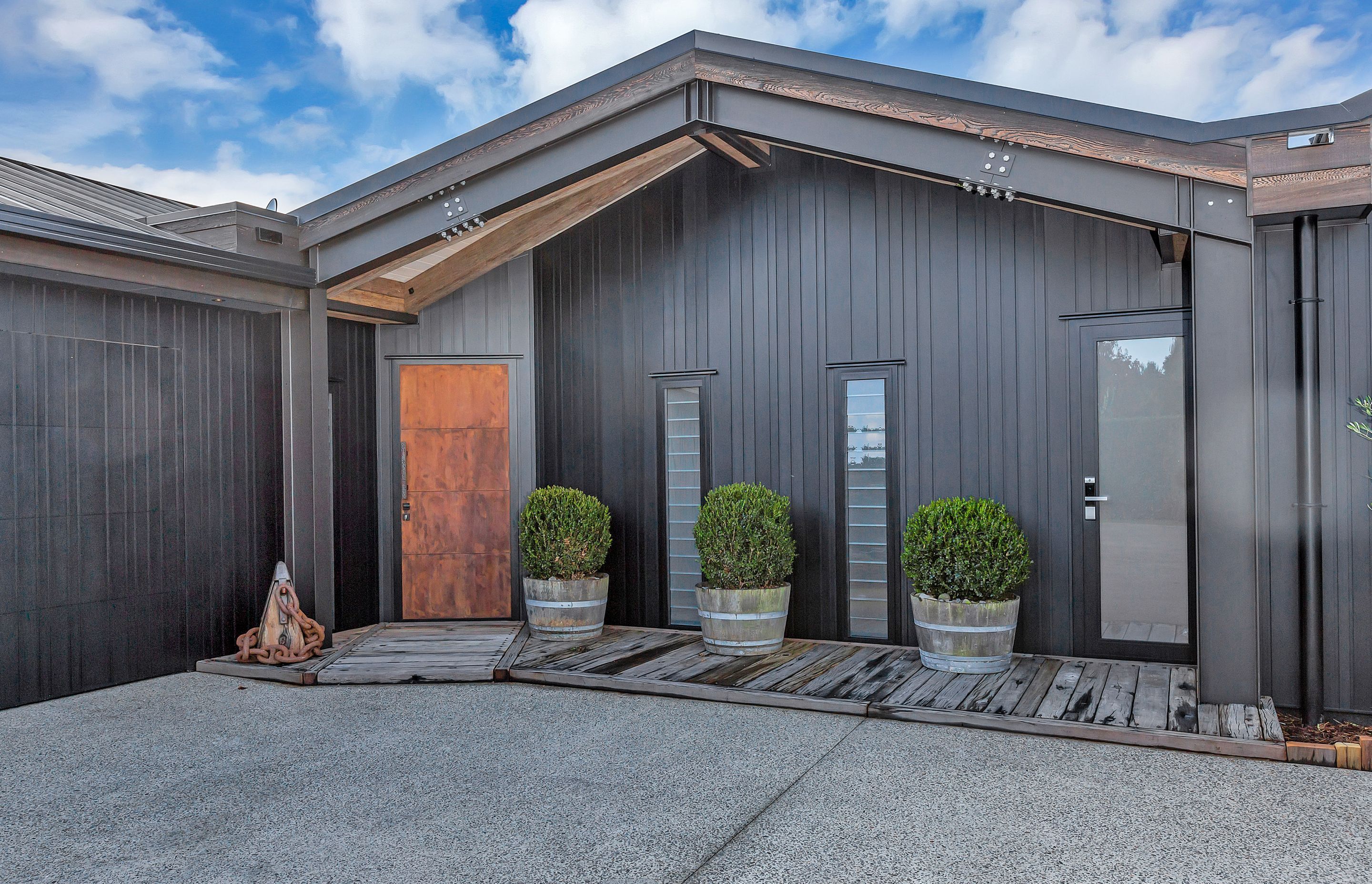 The main entrance provides a taster of the crafted interior, with its strking brass front door and recycled Tasmanian ironbark timber from the old Wellington tug boat wharf.