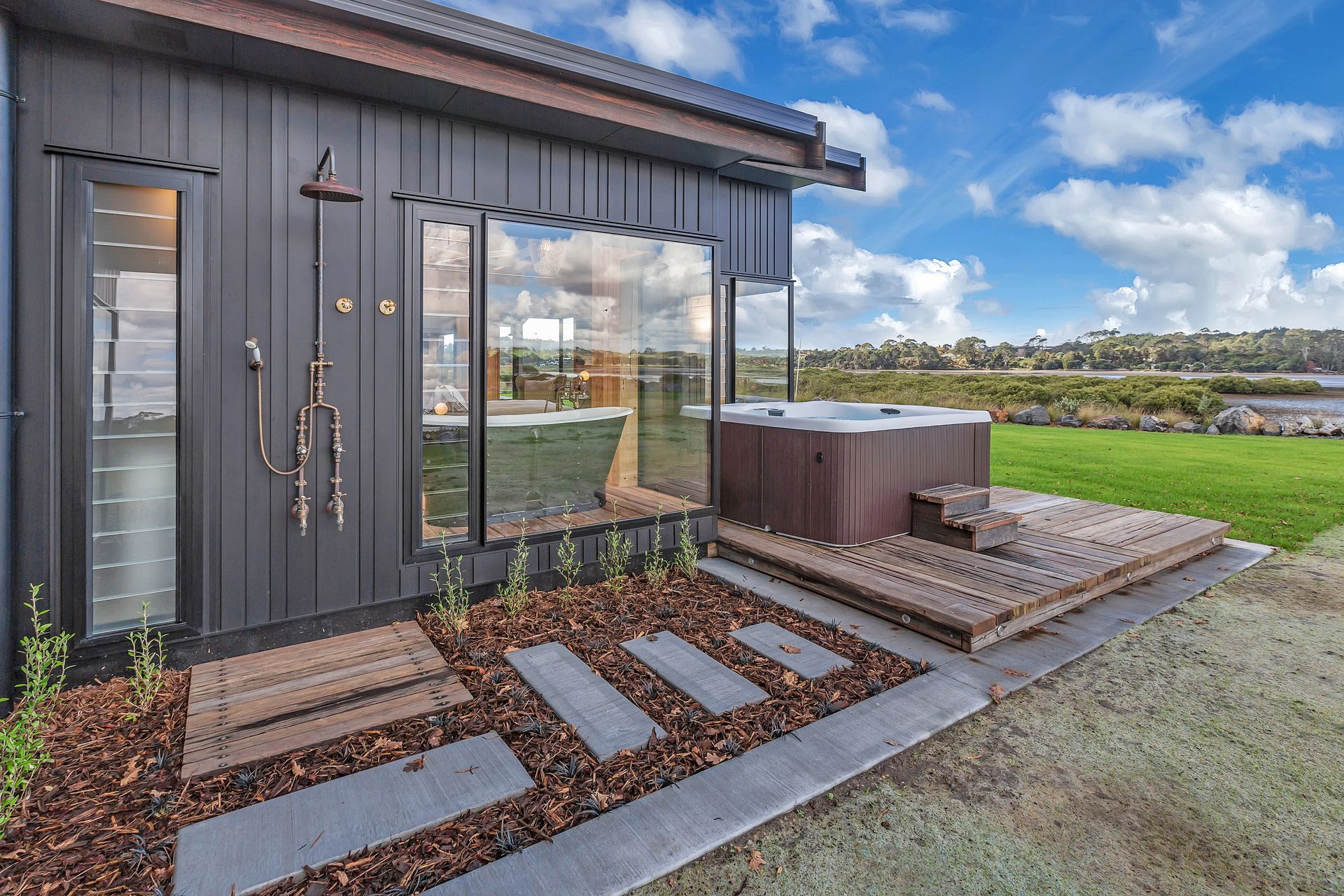 An outdoor spa and shower completes this lovingly crafted house that offers an idyllic lifestyle right next to the waterfront.