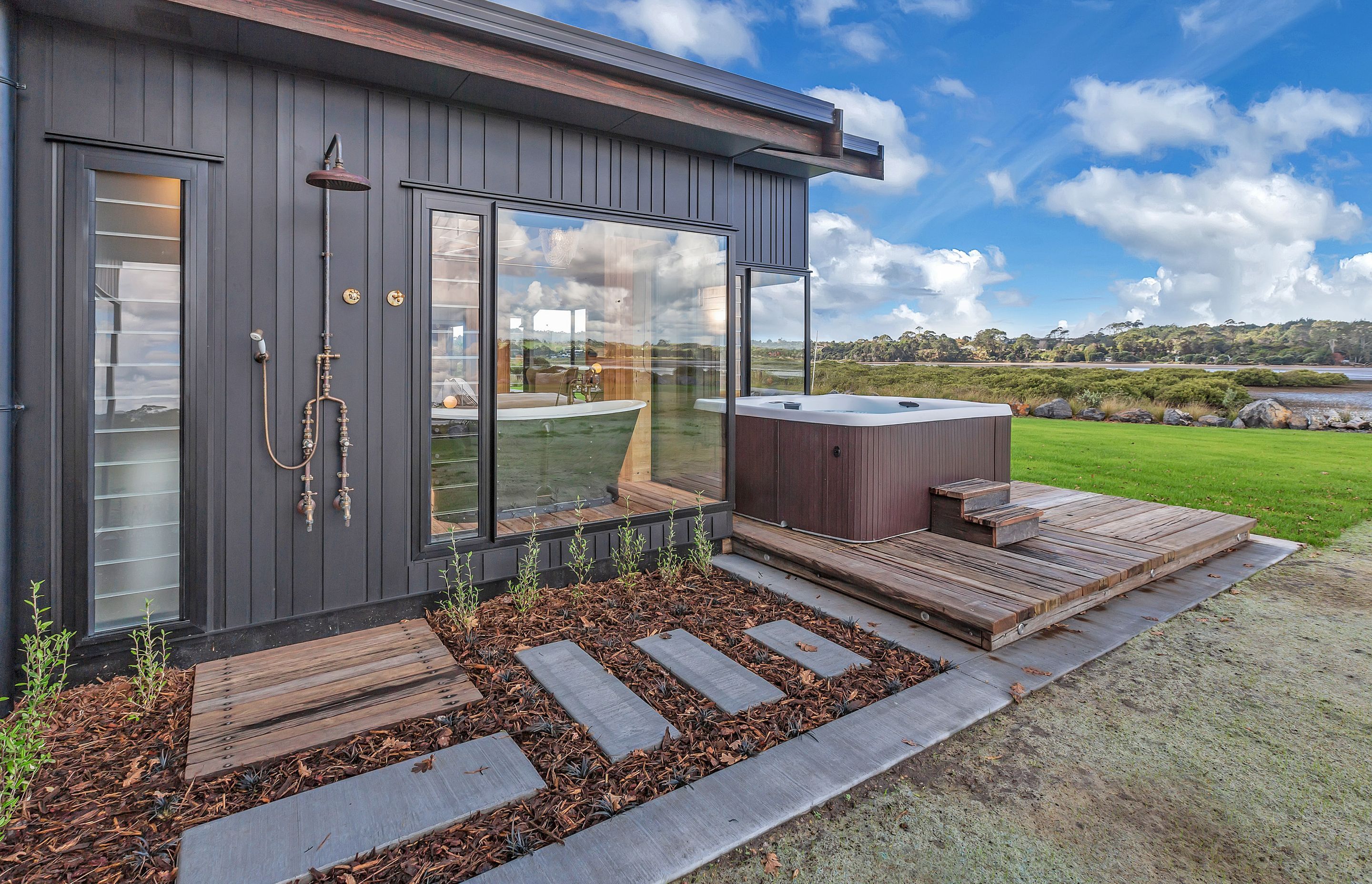 An outdoor spa and shower completes this lovingly crafted house that offers an idyllic lifestyle right next to the waterfront.